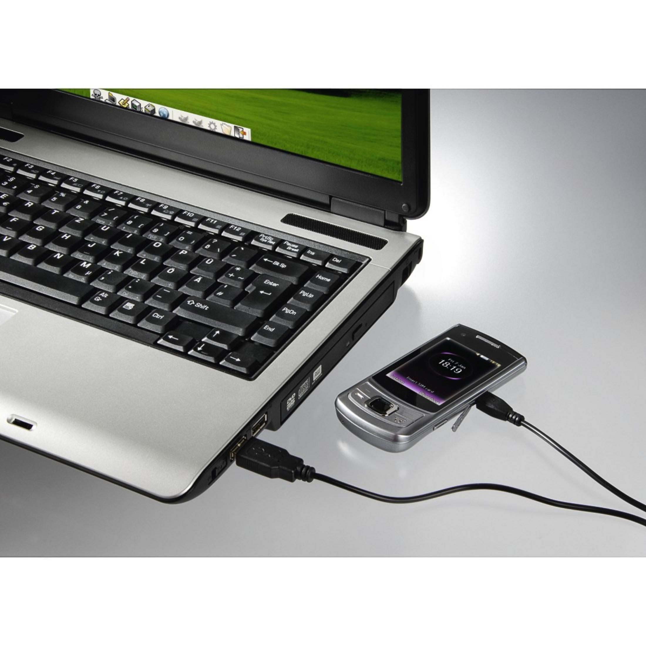 Portátil conectado a un teléfono, cable negro, portátil gris, fondo blanco, tecnología.