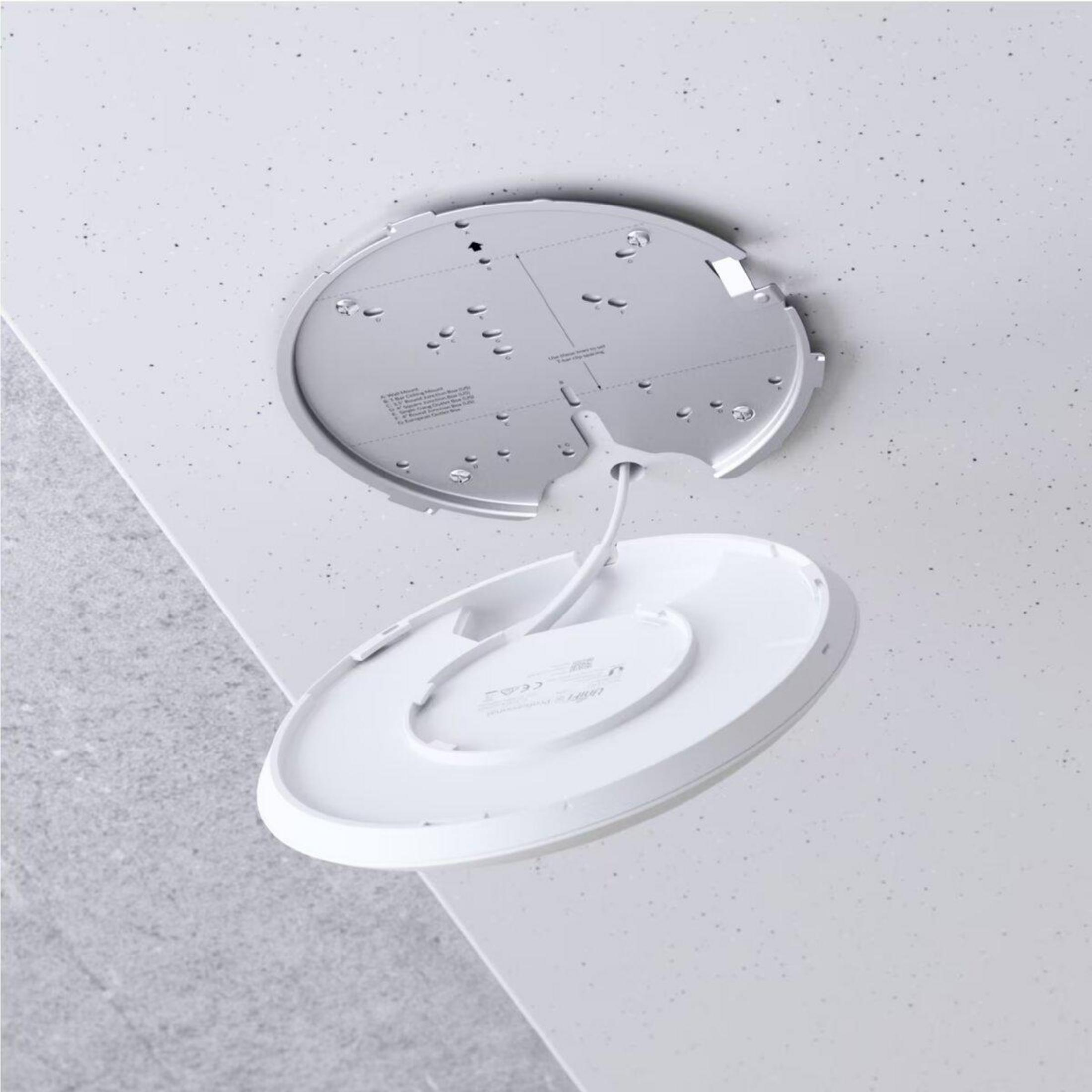 Biała lampa sufitowa o zakrzywionej konstrukcji.