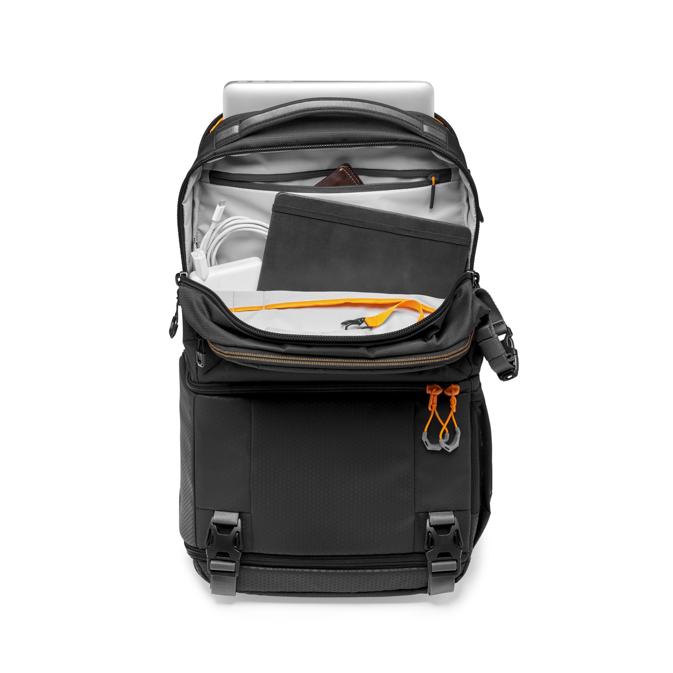 Un sac à dos noir ouvert révélant son contenu : ordinateur portable, câbles, batterie externe et portefeuille.