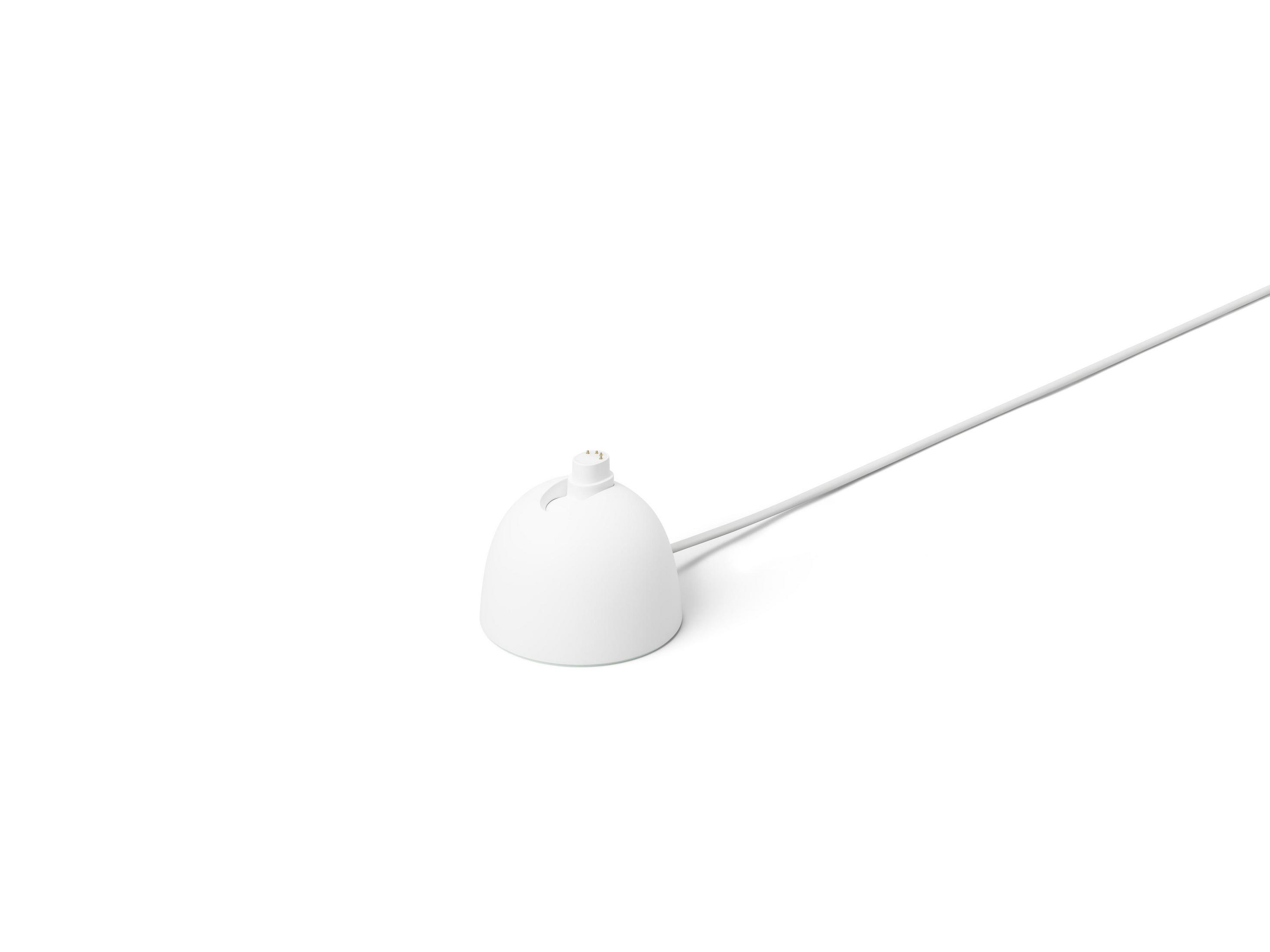 Base de carga blanca con un cable de carga blanco que se extiende desde ella.