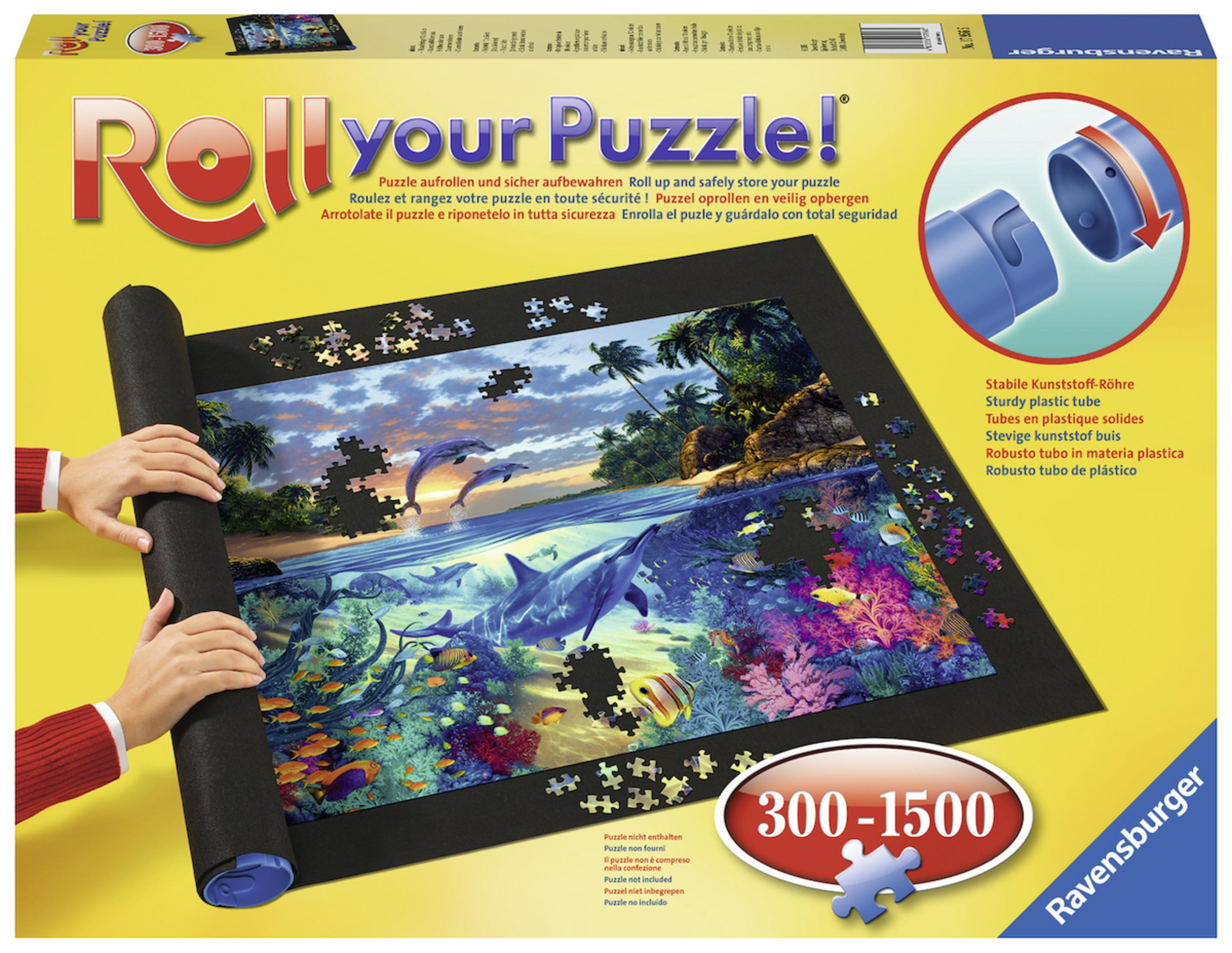 Eine Puzzleteppich mit Delfinszene ist aufgerollt. Eine Schachtel mit einem Puzzle darauf. Weißer Hintergrund.