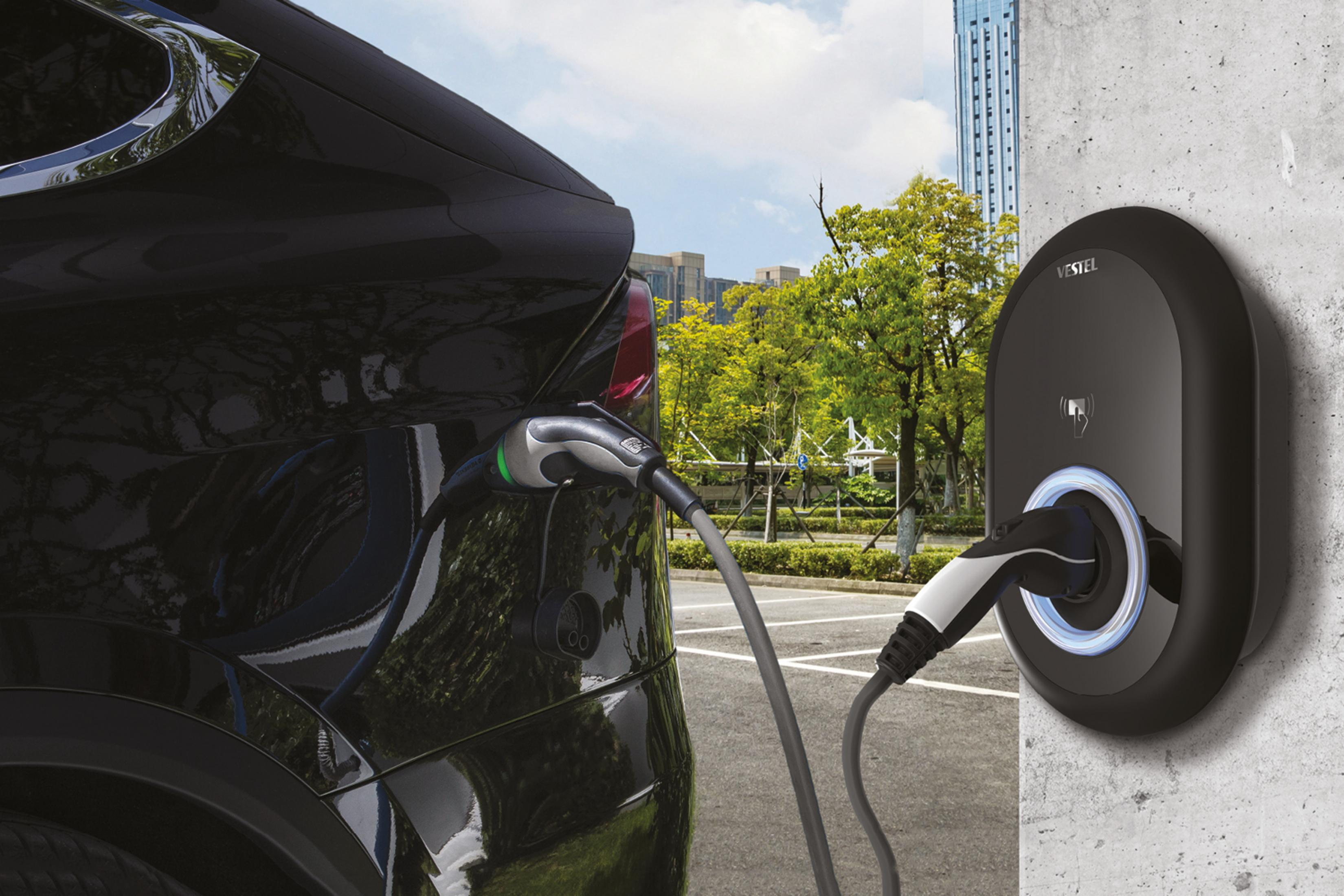 Schwarzes Auto wird geladen. Vestel Ladegerät an der Wand.