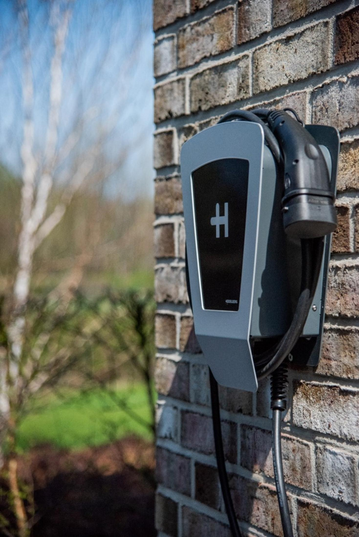 Ladestation für ein Elektroauto an einer Ziegelmauer montiert.