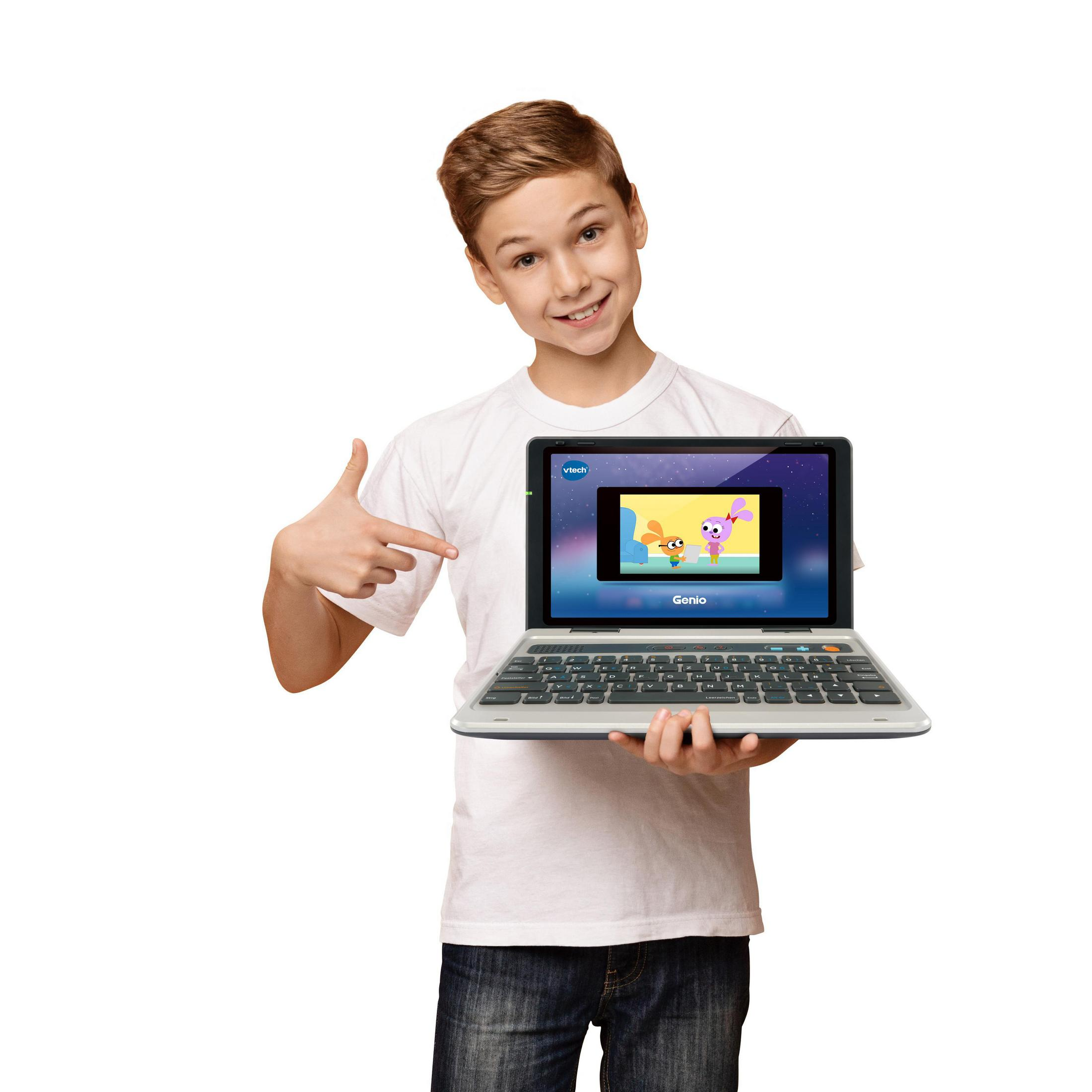 Das Bild zeigt einen Jungen, der einen VTech Genio Laptop mit einem Bildschirm hält, der eine Schnittstelle anzeigt.