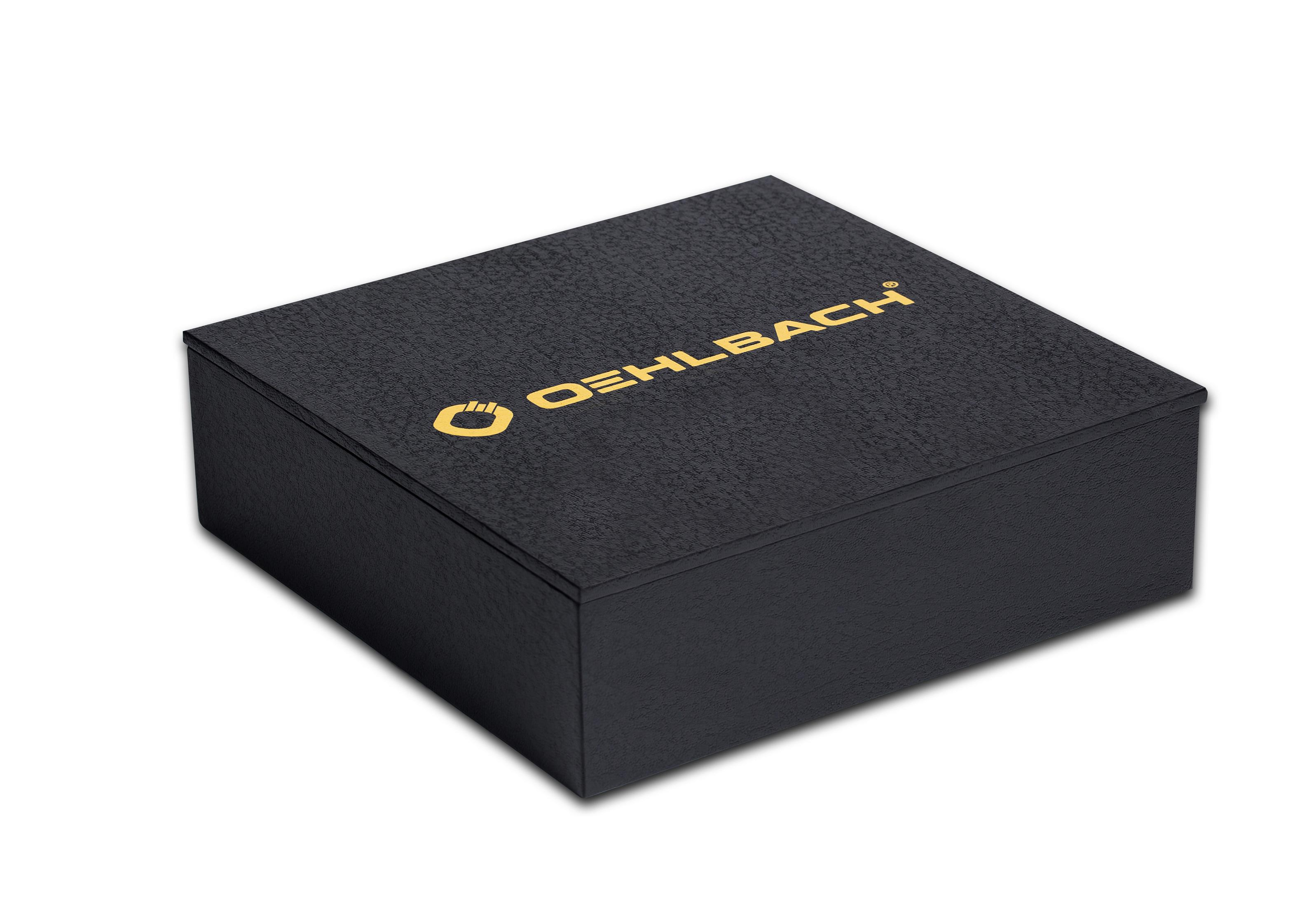 Schwarze Box mit goldenem 'OEHLBACH'-Logo auf der Oberseite, schräg betrachtet.