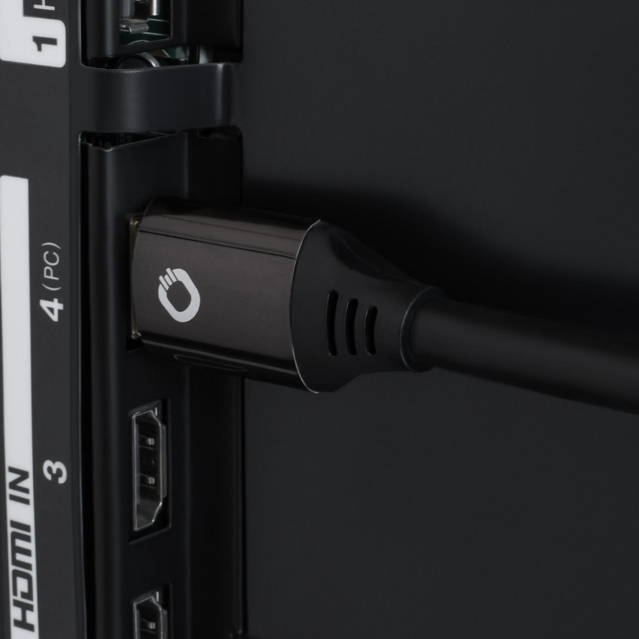 HDMI-Kabel in einen Fernseher eingesteckt, schwarzes Kabel und Stecker sichtbar, auf schwarzer TV-Oberfläche.