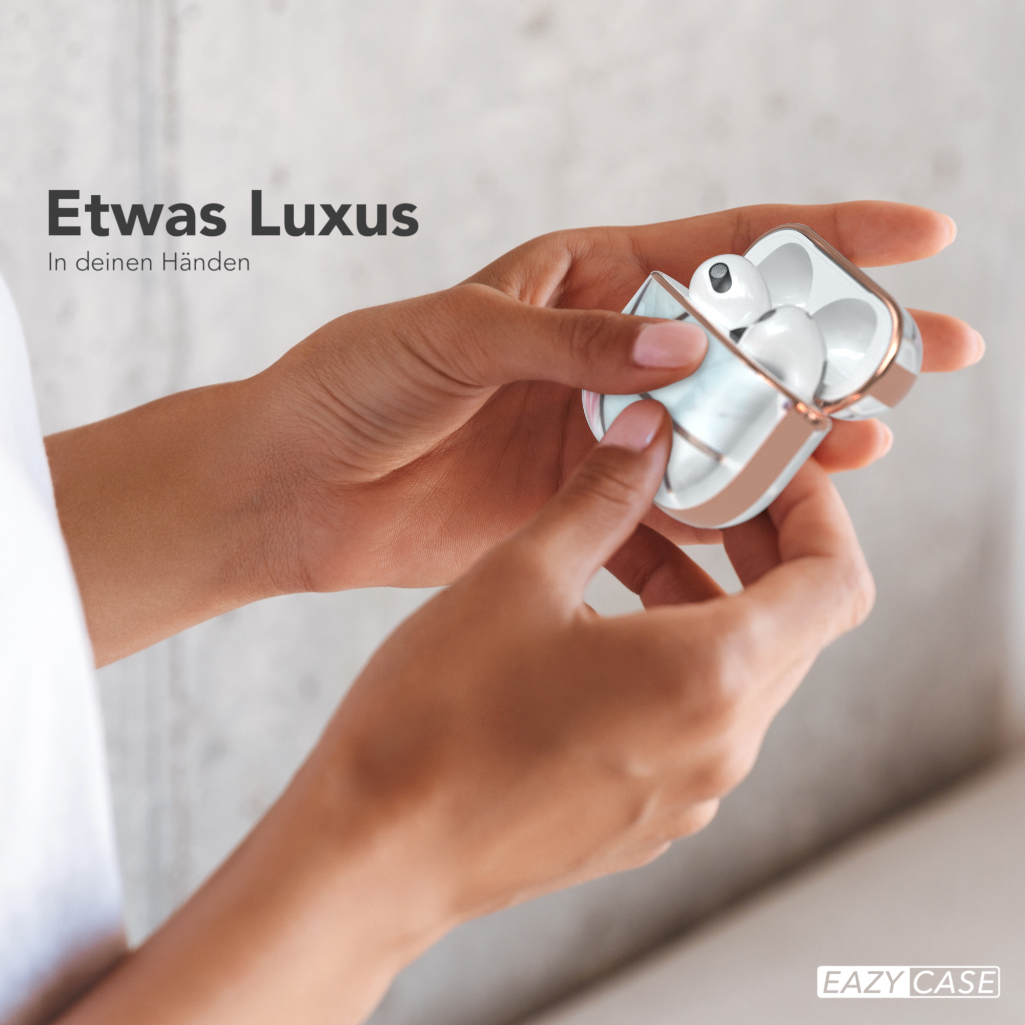 Person hält ein weißes Ohrhörer-Etui, mit dem Text 'Etwas Luxus'.