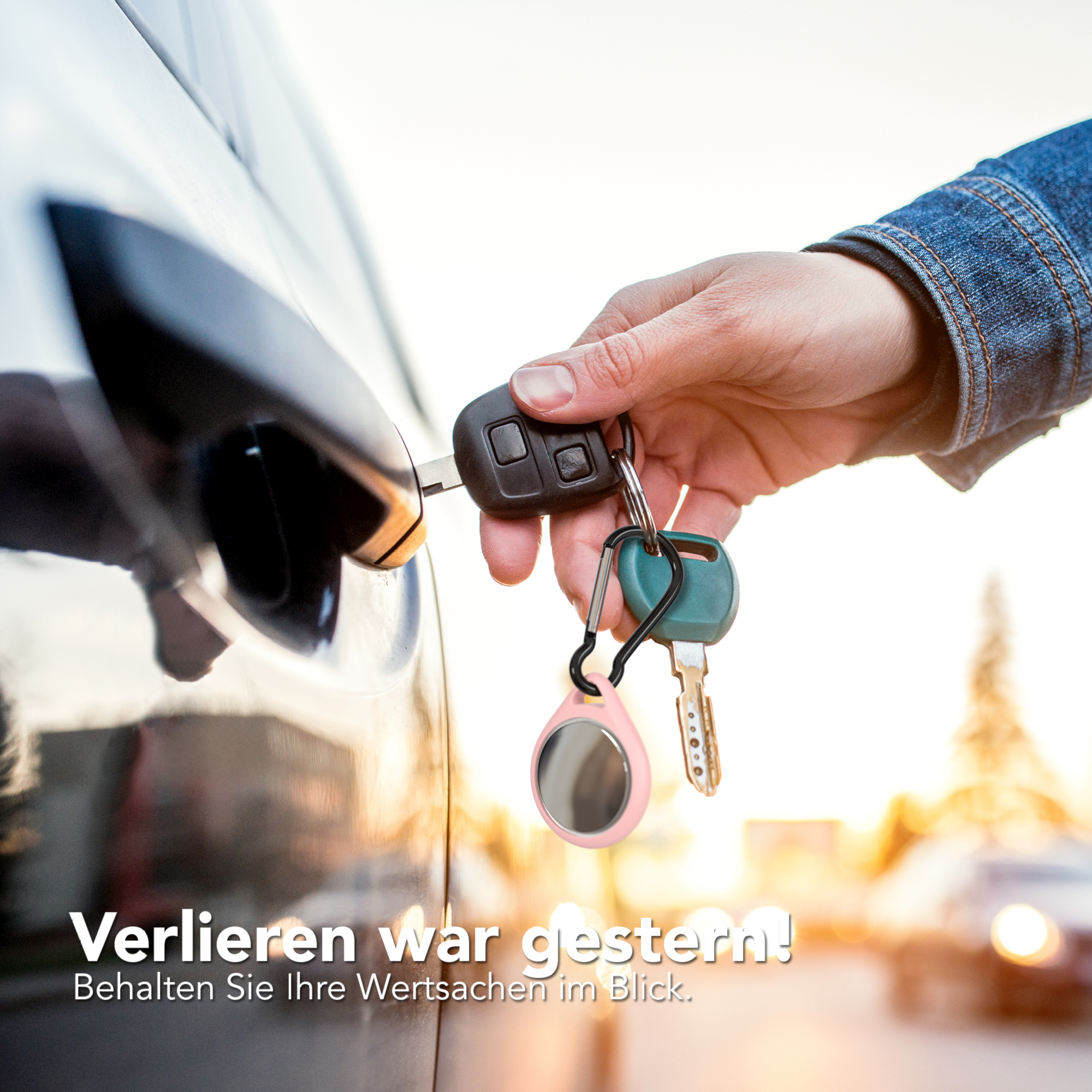 Hand, die einen Schlüssel in das Türschloss eines Autos steckt. Ein Schlüsselanhänger mit Schlüsseln und einem rosa Tracker.