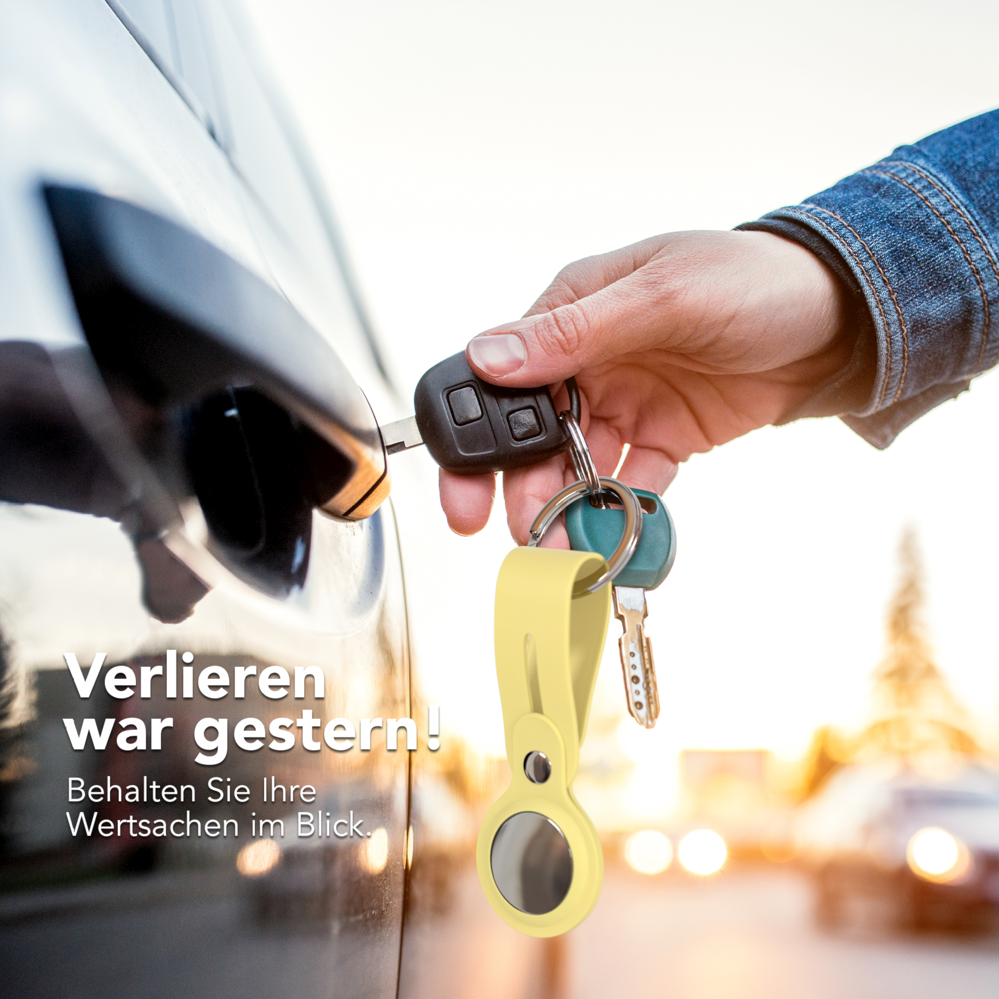 Eine Hand steckt einen Schlüssel in eine Autotür. Ein gelber Schlüsselanhänger hängt unter den Schlüsseln.