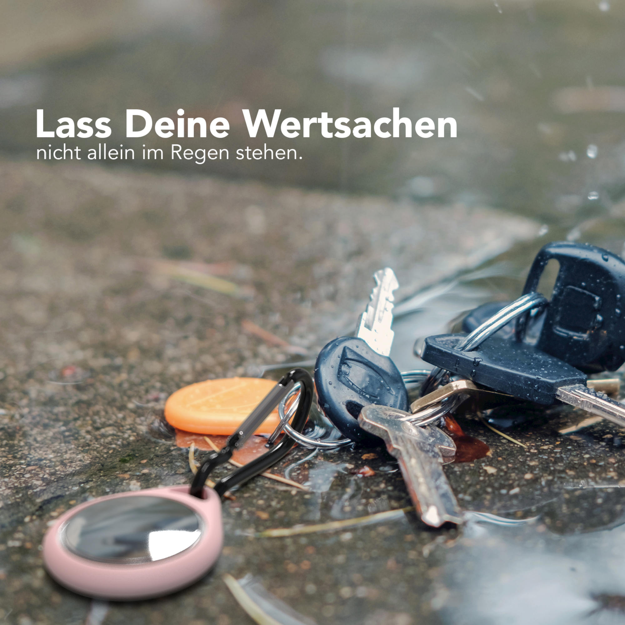 Schlüssel auf nassem Untergrund mit pinkfarbenem Anhänger, Regen fällt. Text: Lass deine Wertsachen nicht im Regen stehen.