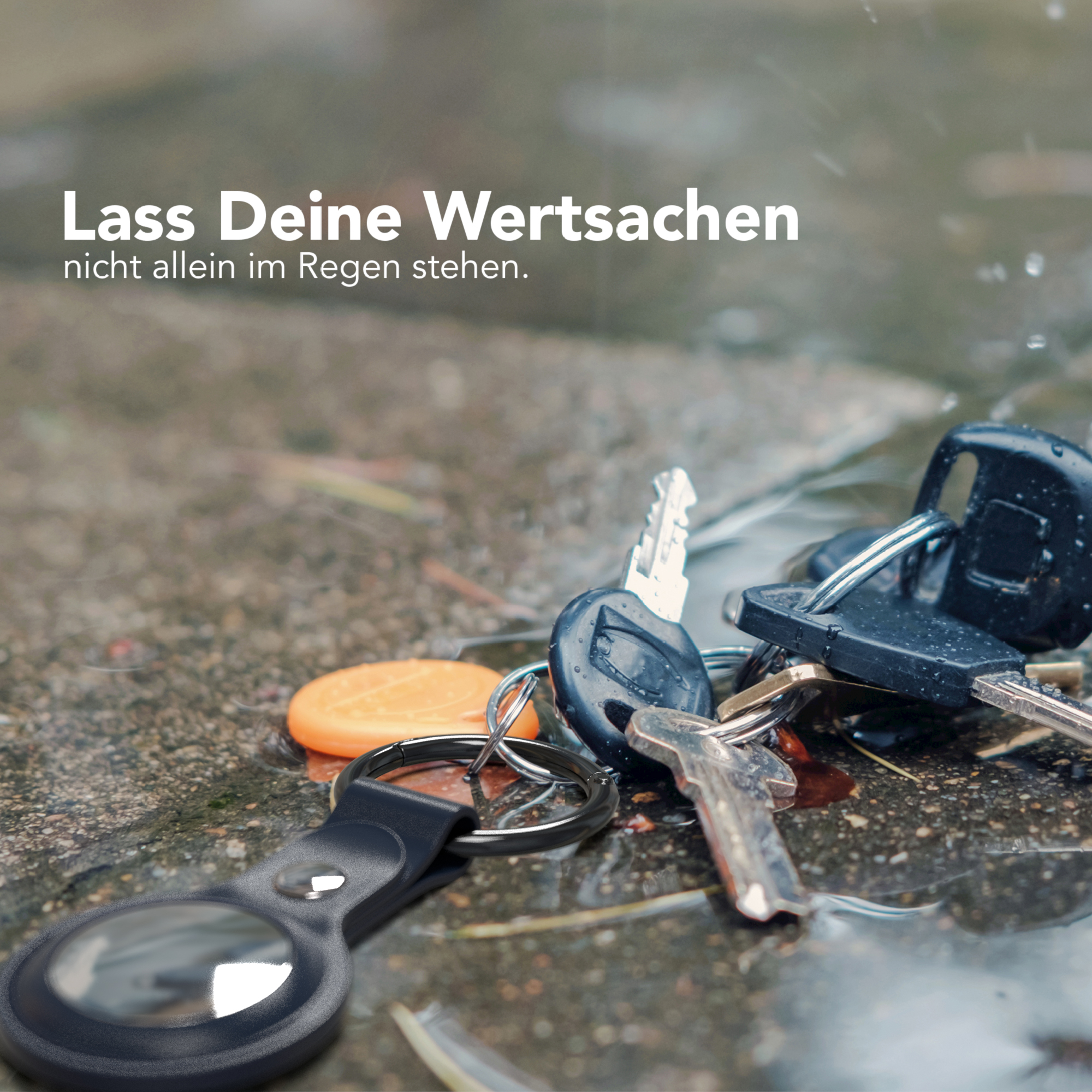 Schlüssel auf nassem Boden. Text: Lassen Sie Ihre Wertsachen nicht im Regen stehen. Schlüsselanhänger.