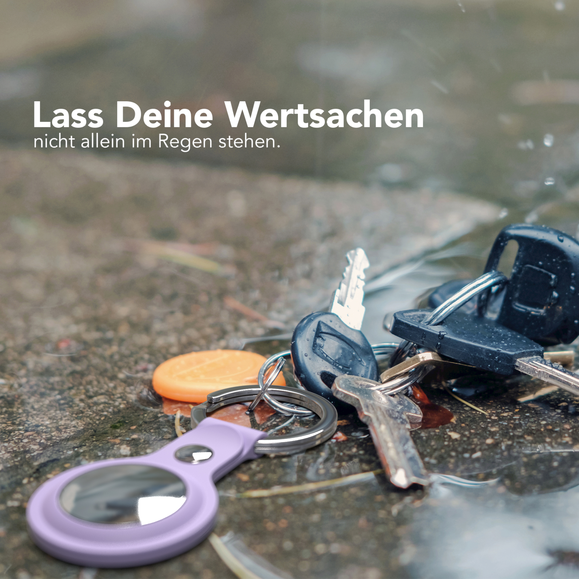 Schlüssel und Schlüsselanhänger auf nasser Oberfläche. Regen fällt.