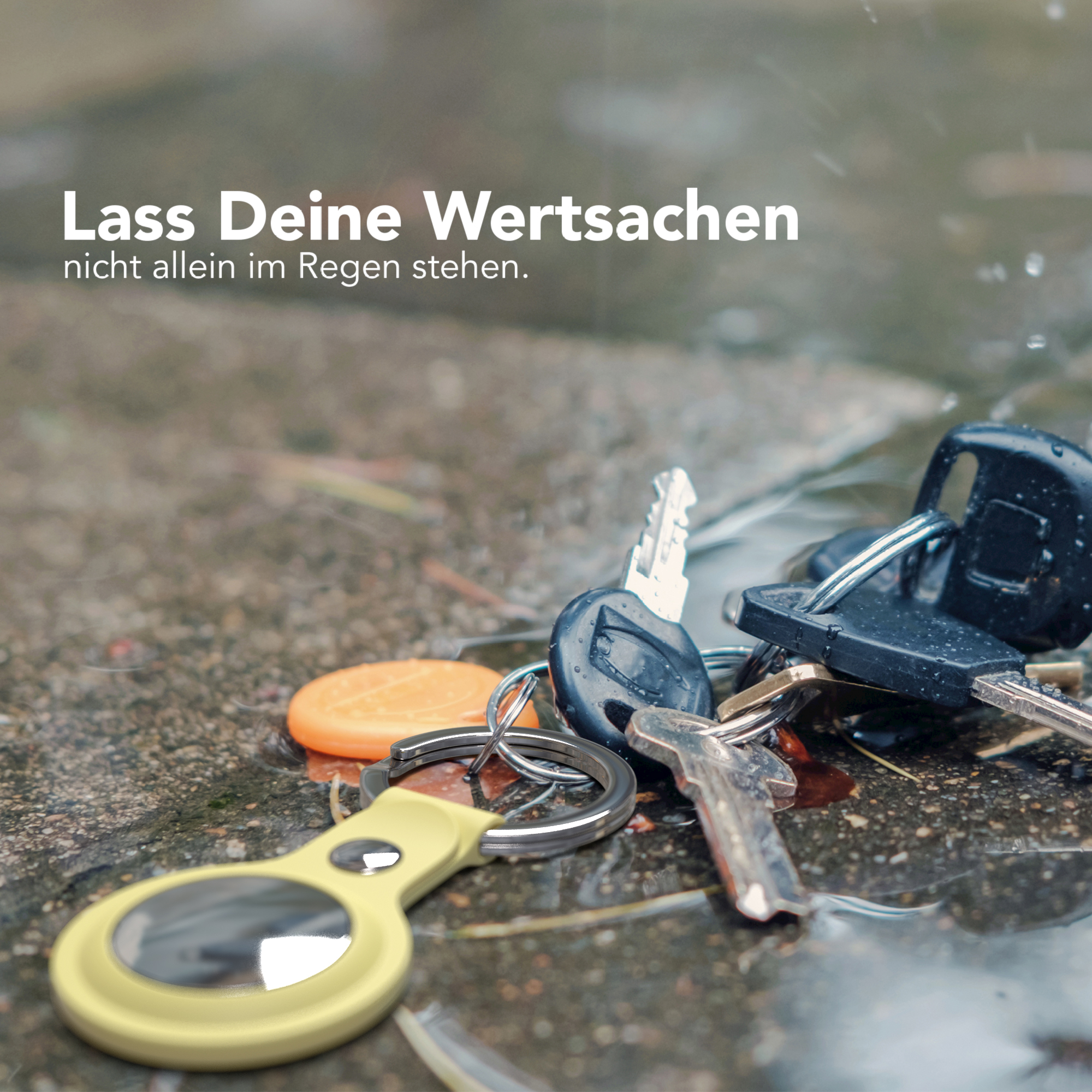 Schlüssel auf nasser Oberfläche mit gelbem Schlüsselanhänger und Text 'Lass Deine Wertsachen'.