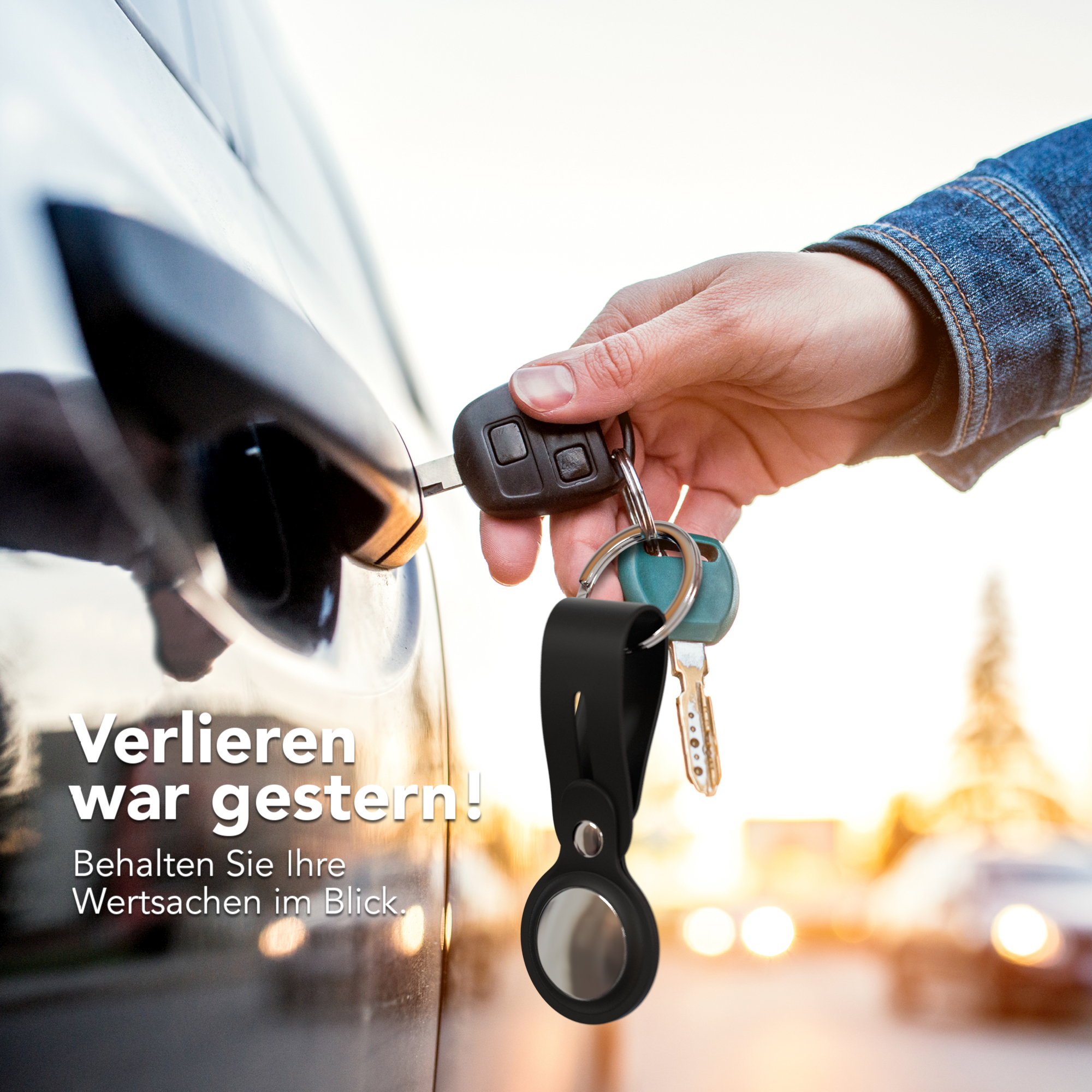 Eine Hand entriegelt eine Autotür mit Schlüsseln und einem schwarzen Schlüsselanhänger mit Anhänger.