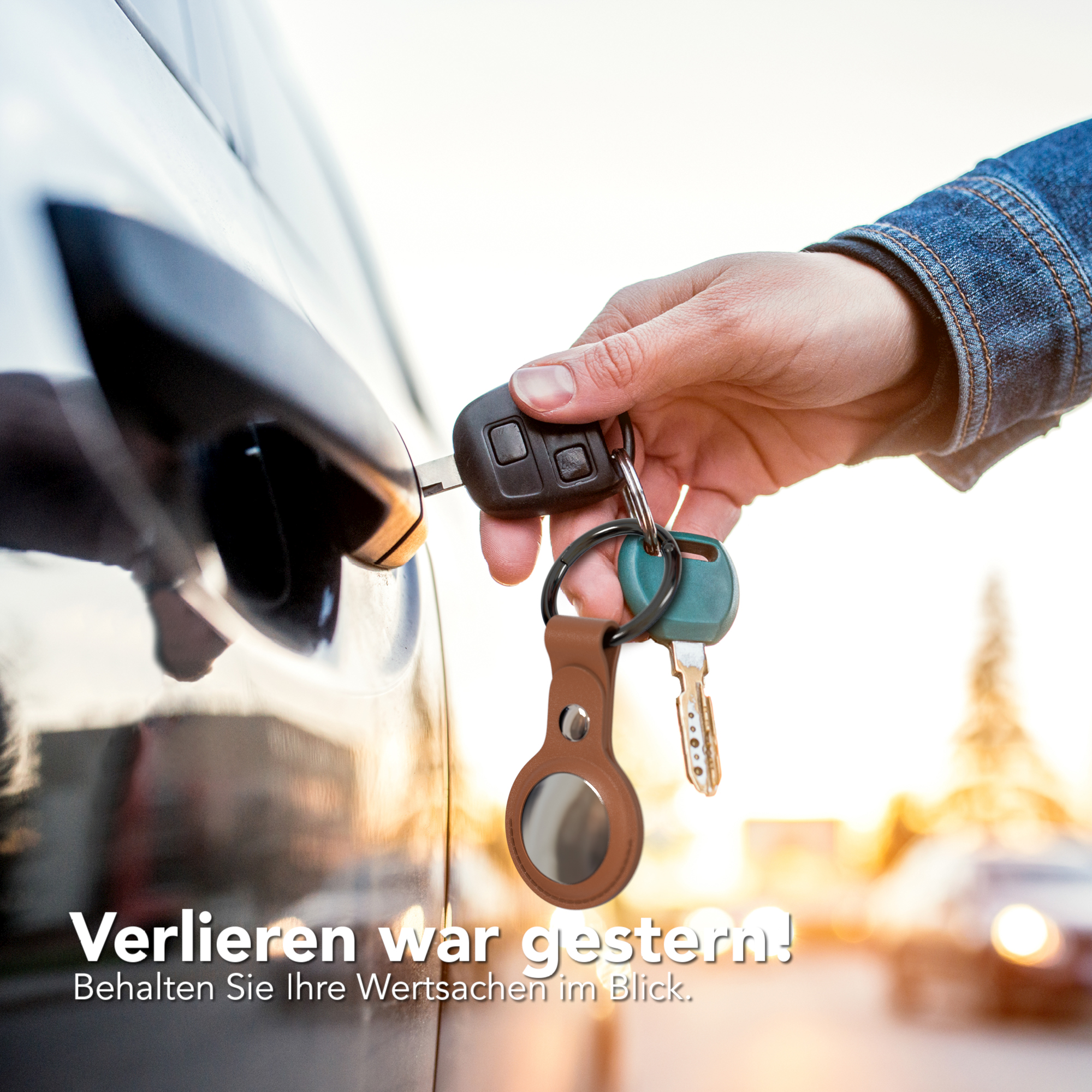 Eine Hand steckt einen Schlüssel in eine Autotür, mit Schlüsseln und Tracker am Schlüsselring.