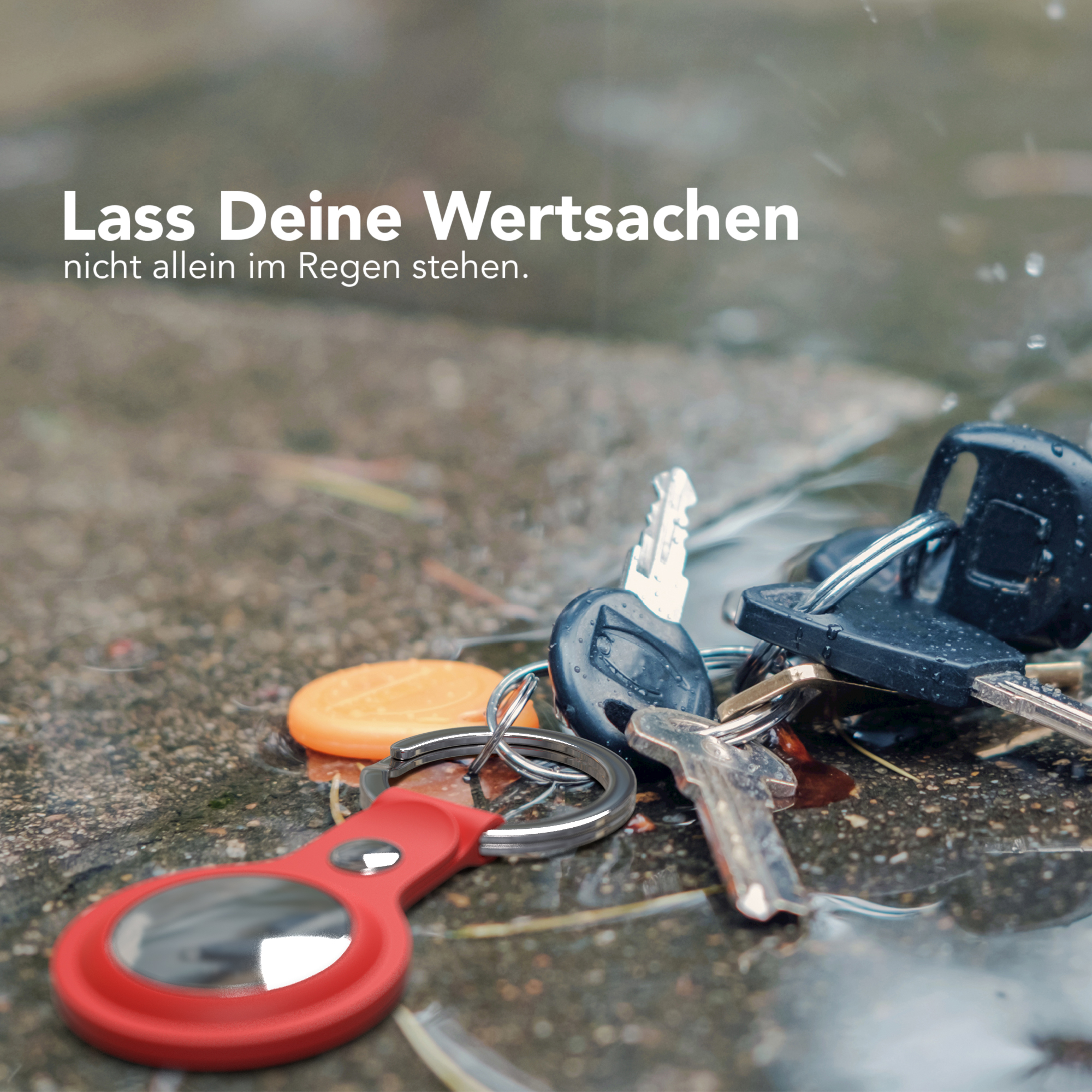 Schlüssel und Schlüsselanhänger auf nasser Oberfläche. Regen fällt.