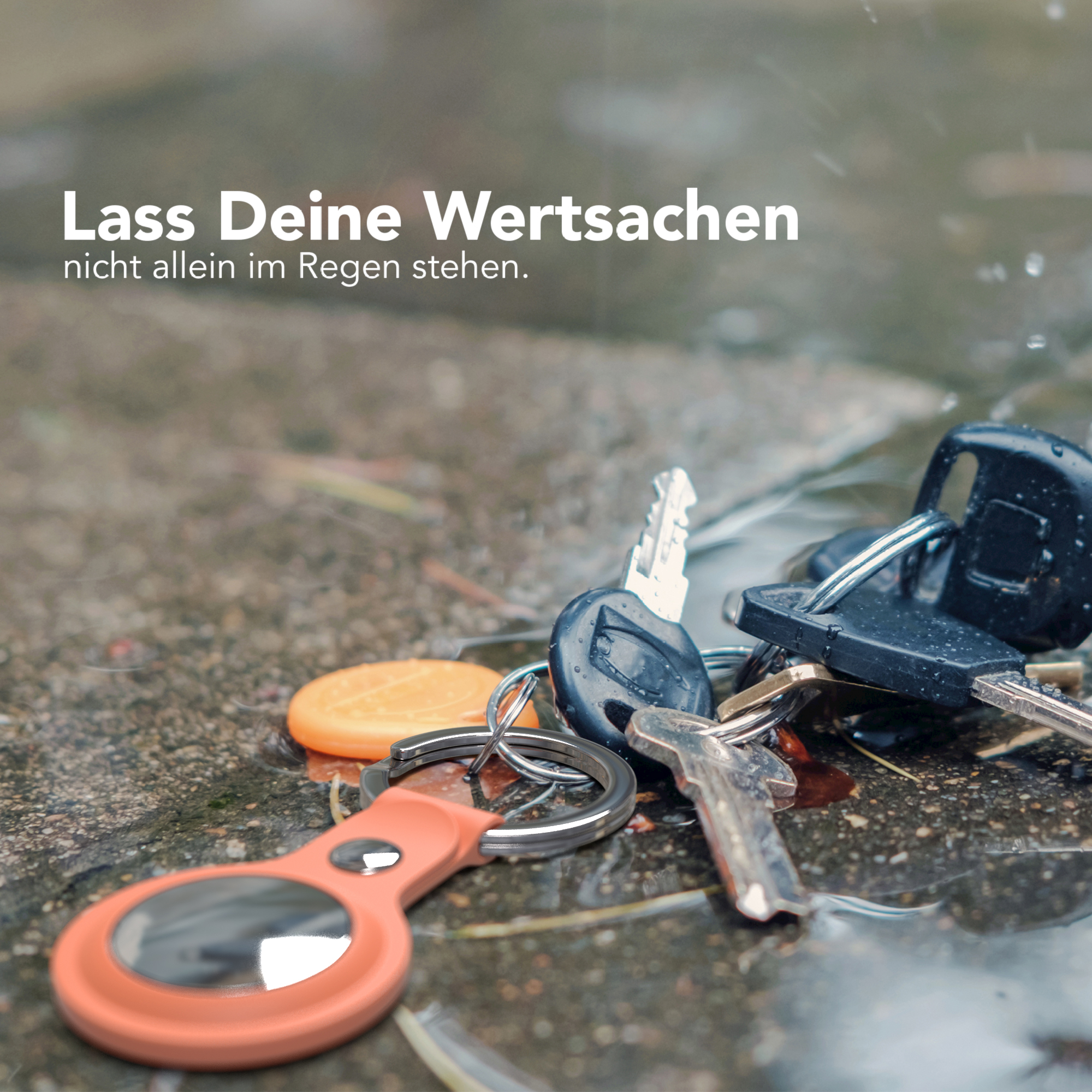 Schlüssel und ein Schlüsselfinder auf einer nassen Oberfläche mit Wassertropfen. Text: "Lass deine Wertsachen..."