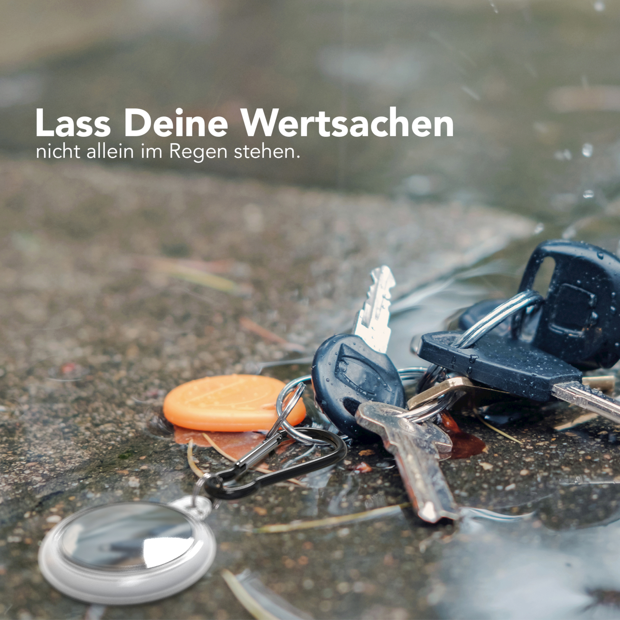 Schlüssel auf nassem Bürgersteig mit unscharfem Hintergrund, Fokus auf die Schlüssel.
