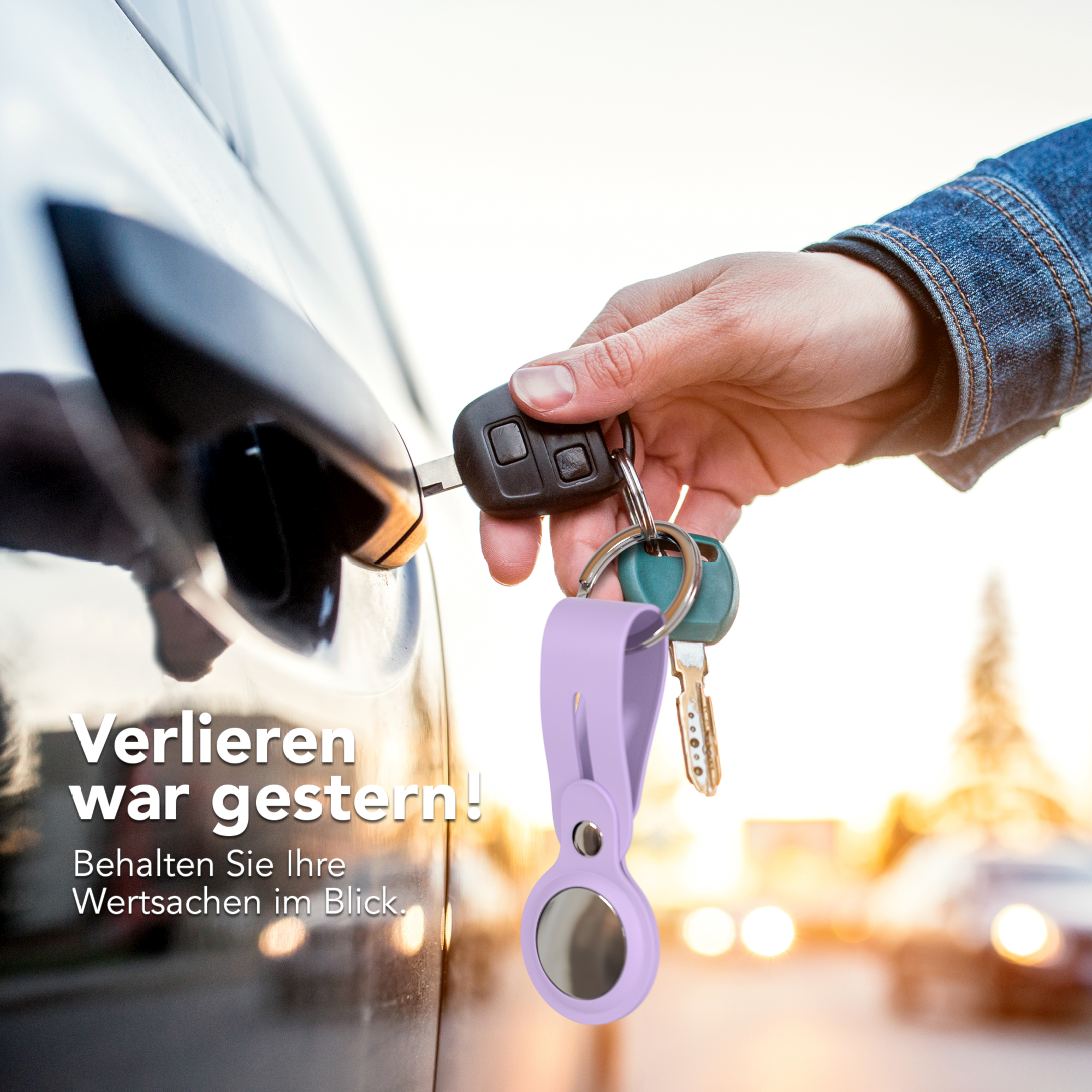 Eine Hand steckt einen Schlüssel in eine Autotür. Ein Schlüsselbund mit Schlüsseln und einem helllila Anhänger ist sichtbar.