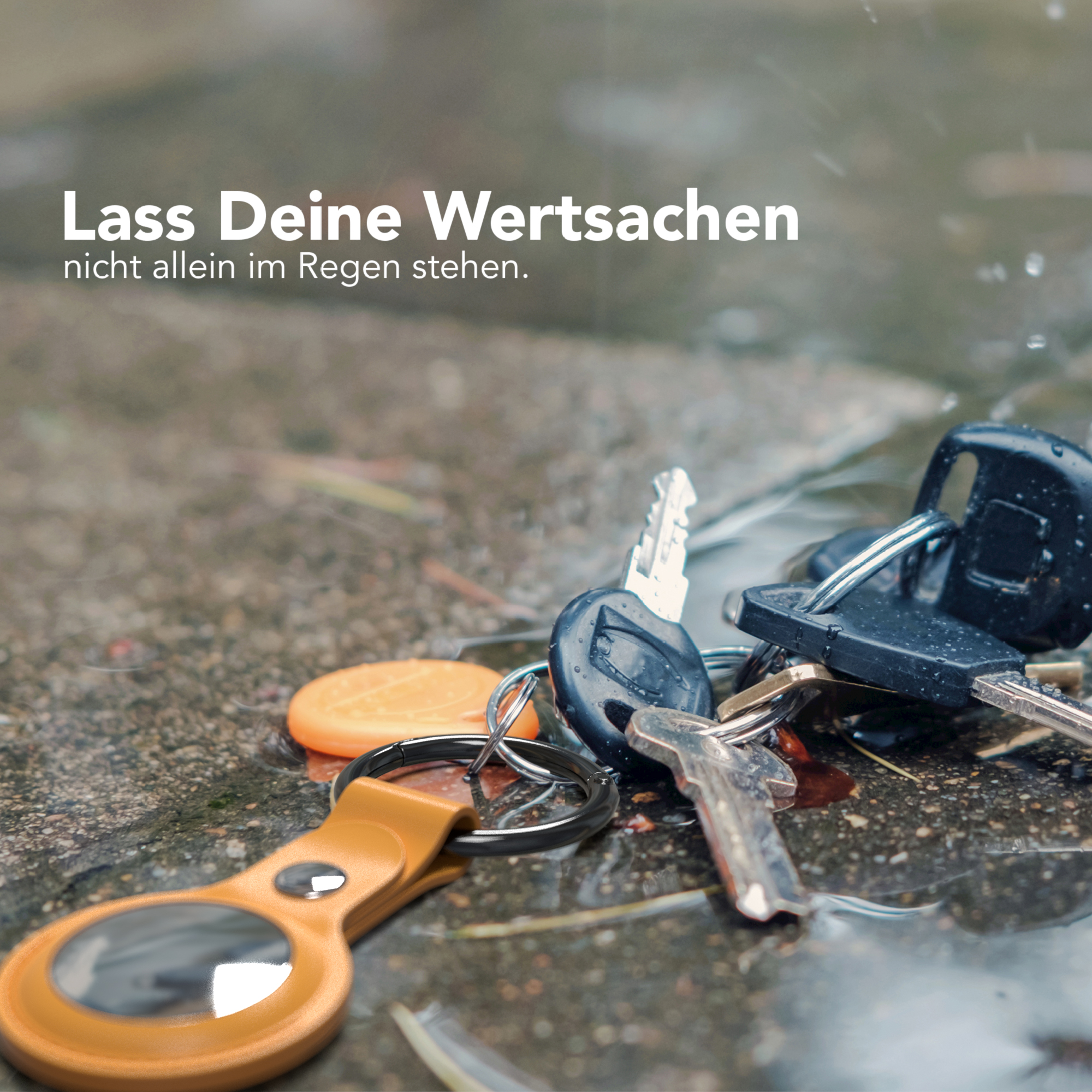 Schlüssel im Regen. Oranges Etikett, Autoschlüssel und Schlüssel mit schwarzen Griffen.