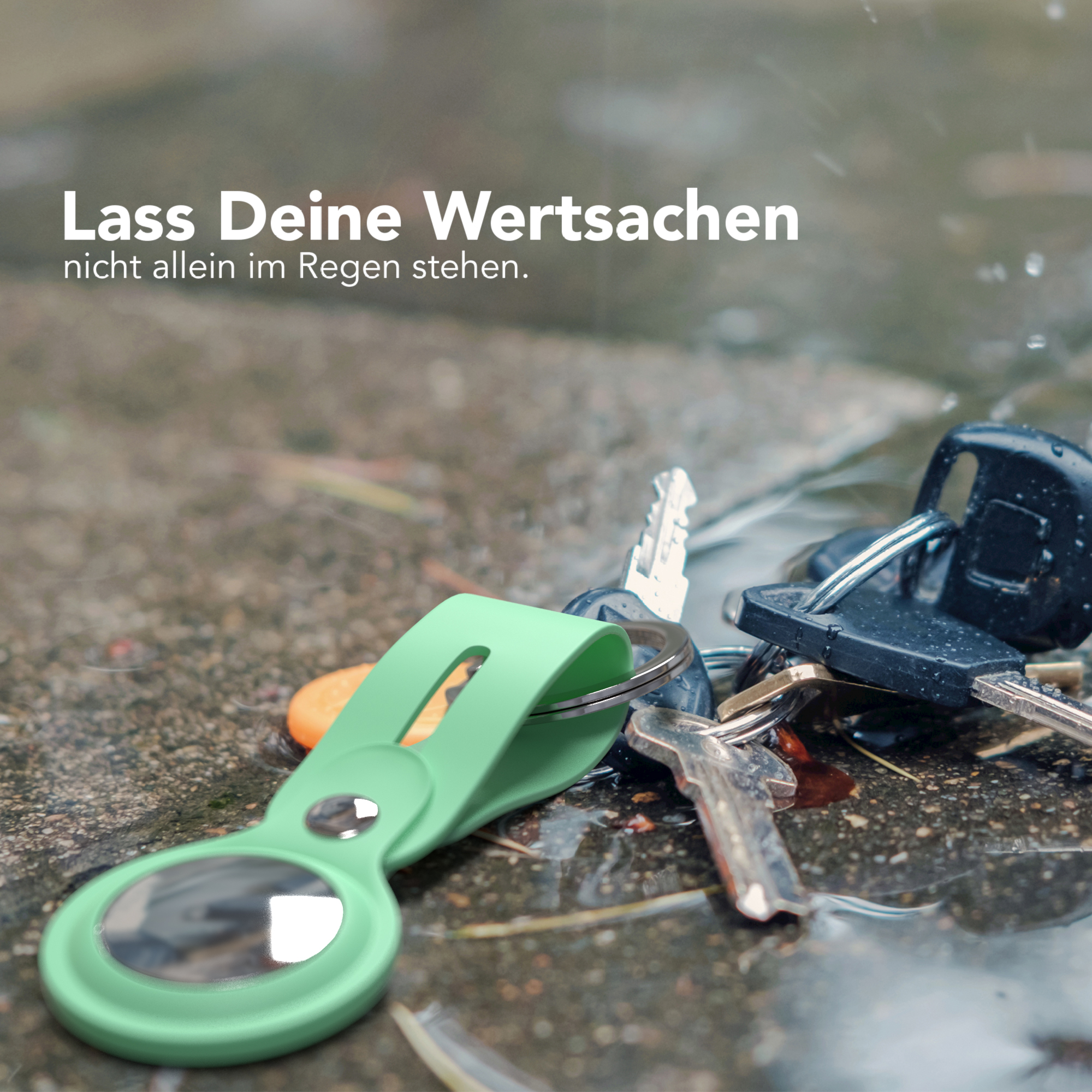 Ein Schlüsselbund und ein grüner Gegenstand in einer Wasserpfütze. Der Text lautet: 'Lass deine Wertsachen nicht im Regen stehen'.