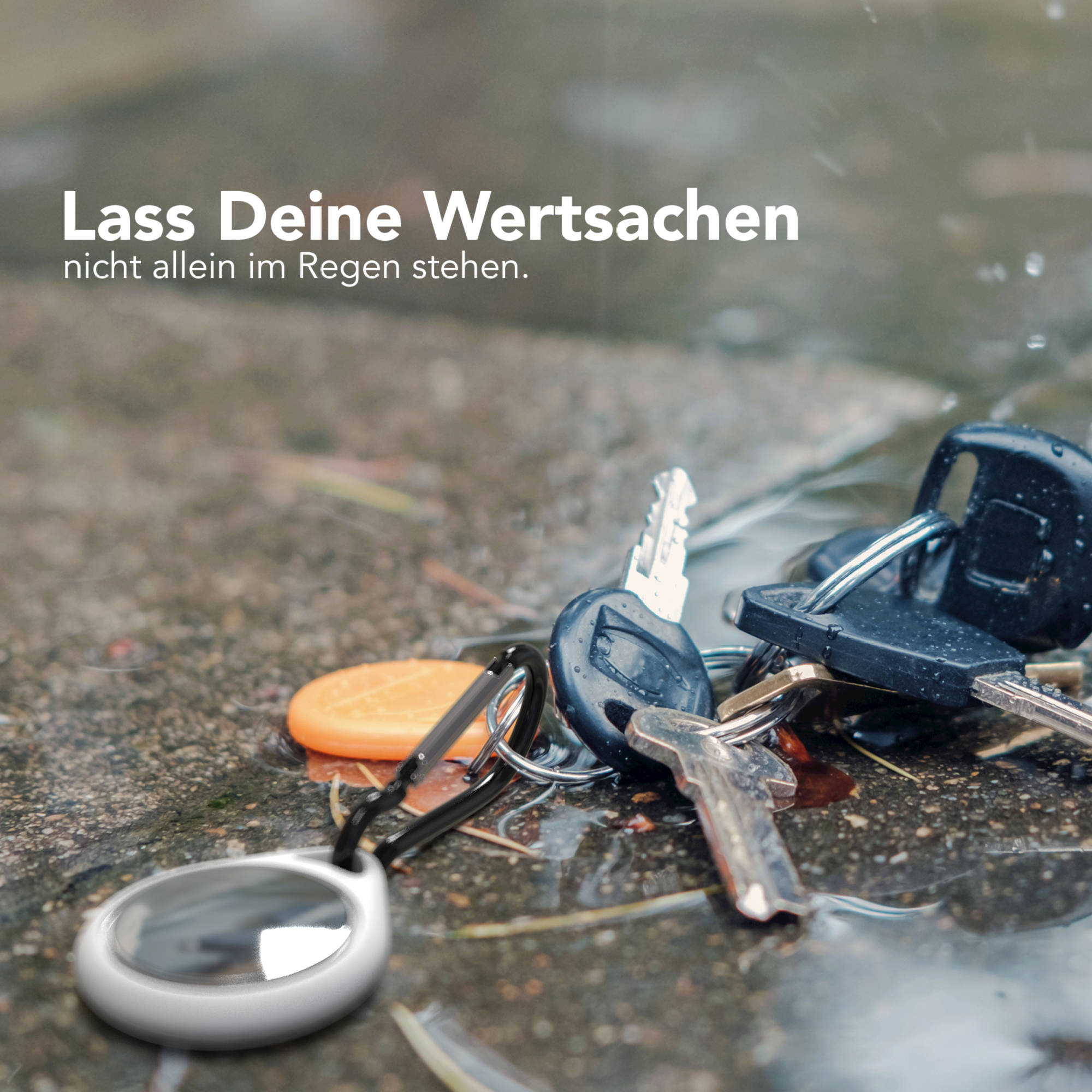 Schlüssel auf nassem Pflaster mit Tracker, ein Slogan auf Deutsch.