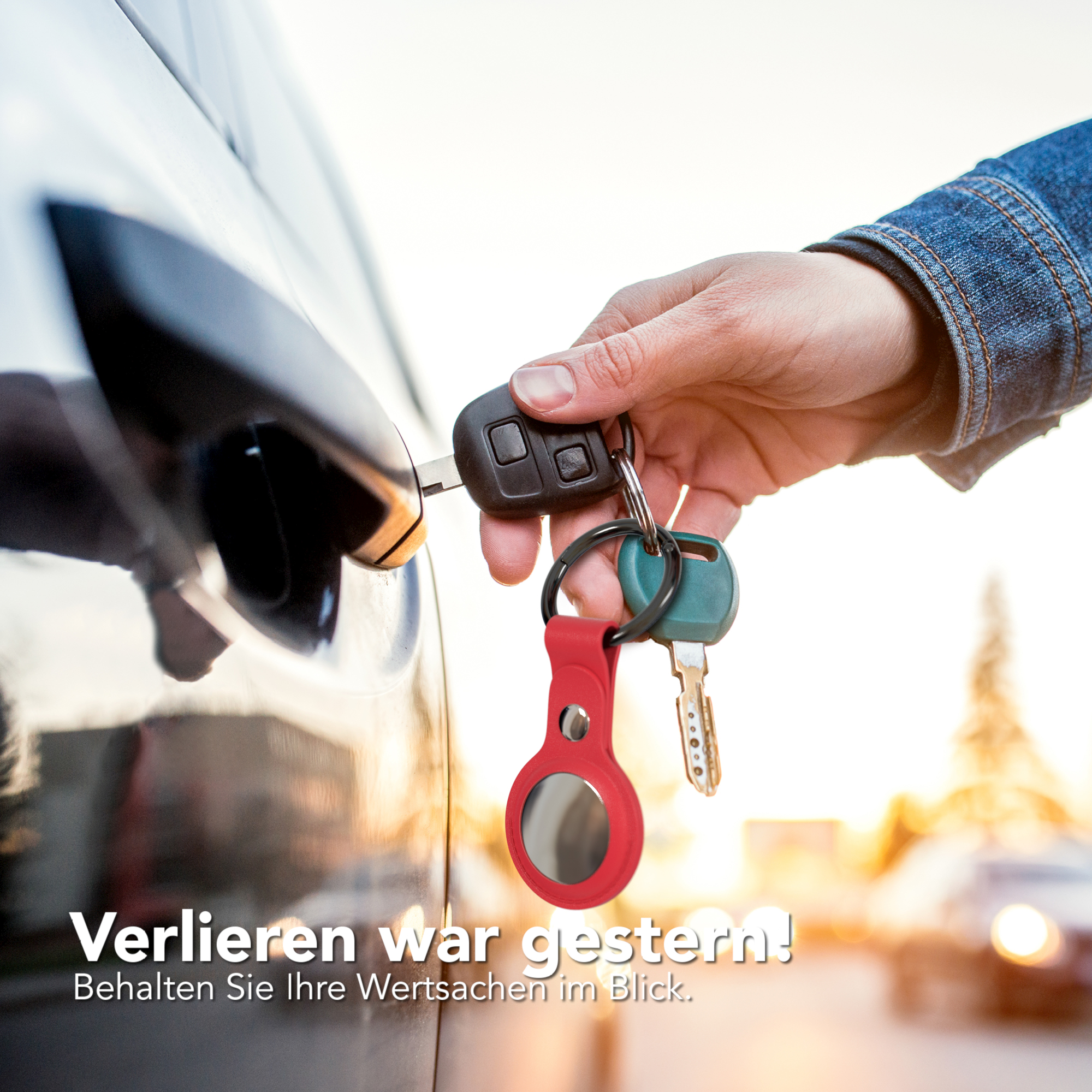 Hand, die einen Schlüssel in das Türschloss eines Autos steckt. Ein Schlüsselanhänger mit Schlüsseln und einem roten Tracker.