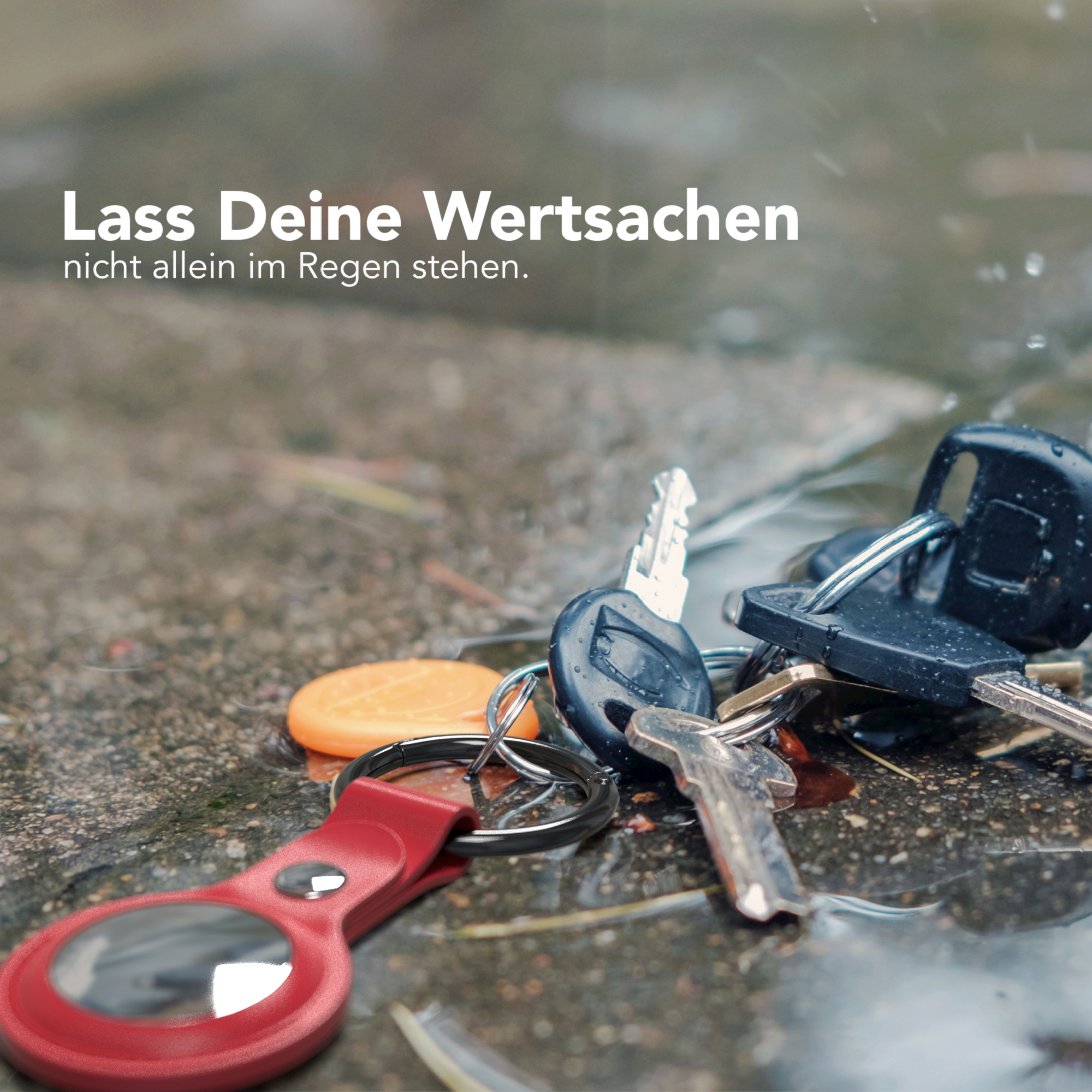Schlüssel auf nassem Bürgersteig mit unscharfem Hintergrund, Fokus auf die Schlüssel.