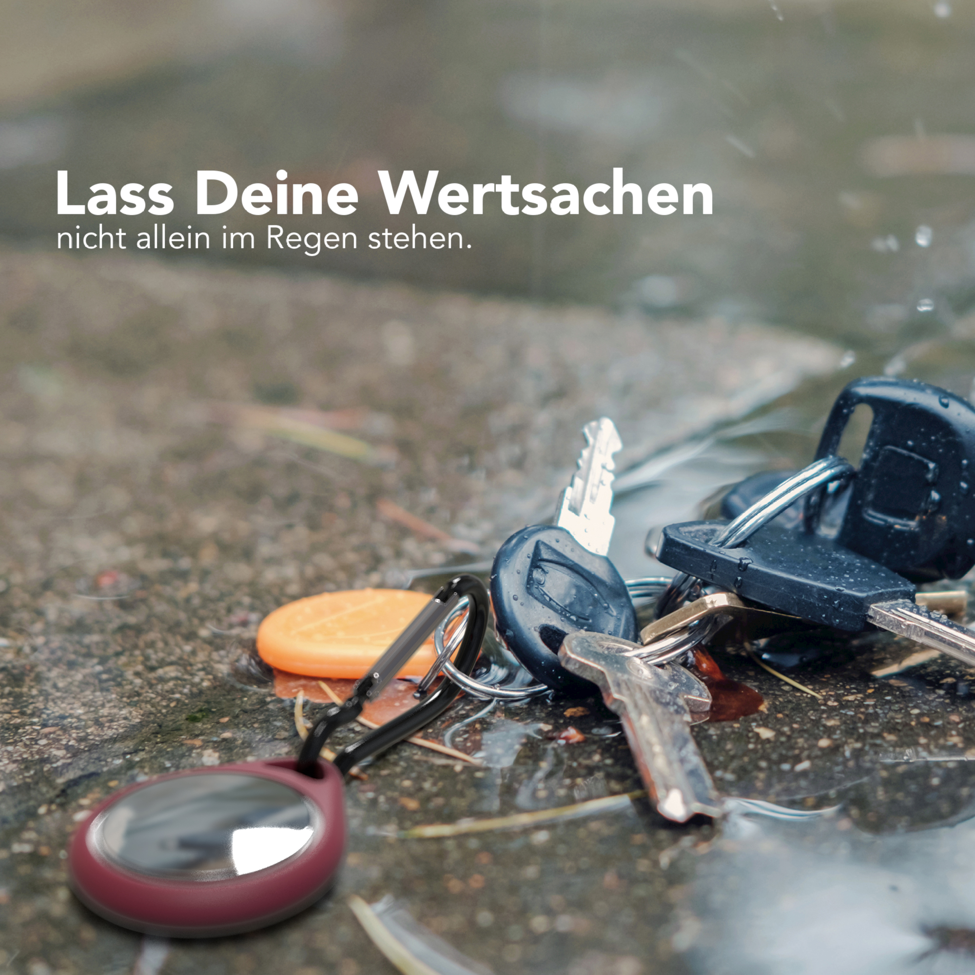 Schlüssel und Zubehör auf nassem Pflaster, mit deutschem Text: 'Lass Deine Wertsachen nicht allein im Regen stehen.'