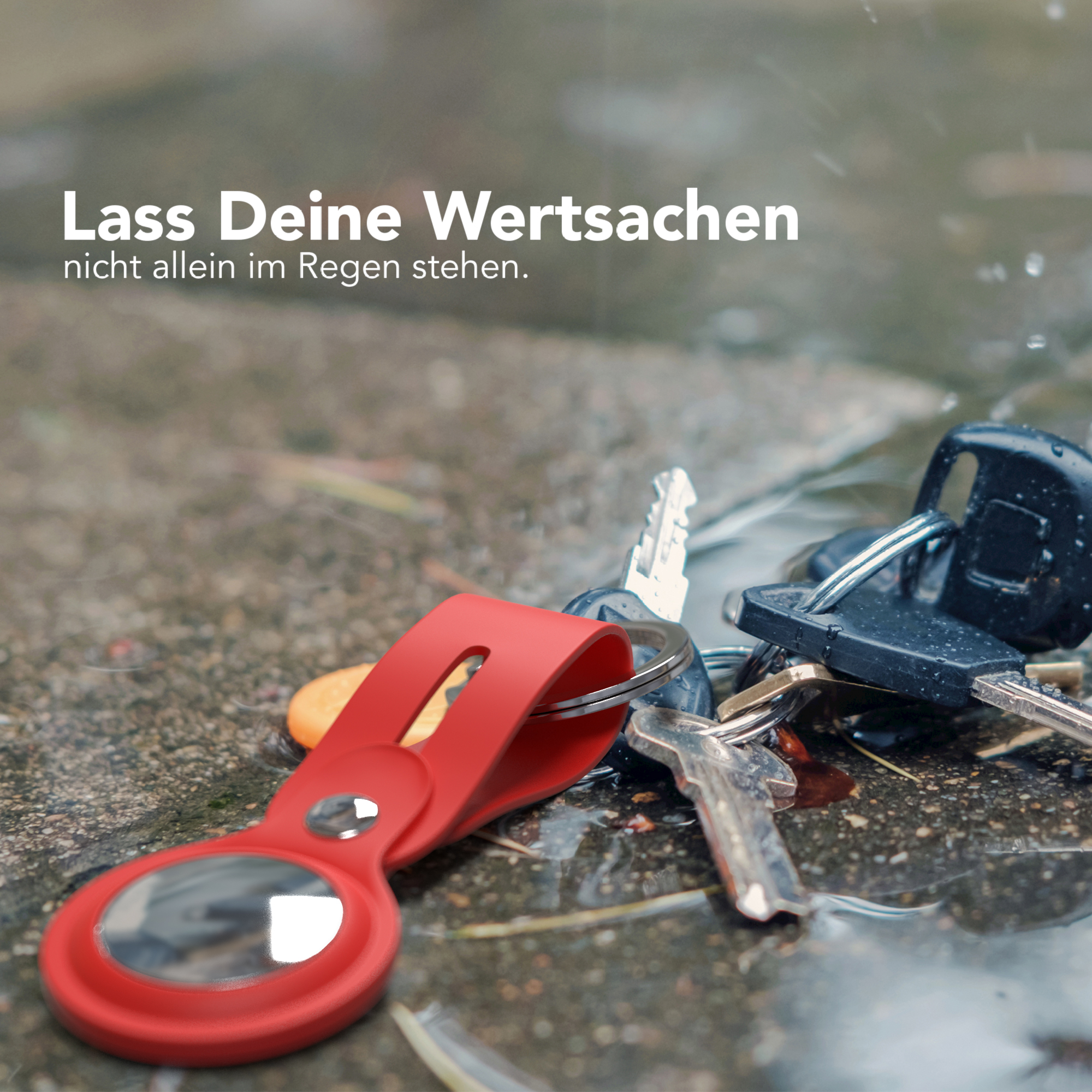 Schlüssel und roter Schlüsselfinder auf nassem Untergrund, mit Text.
