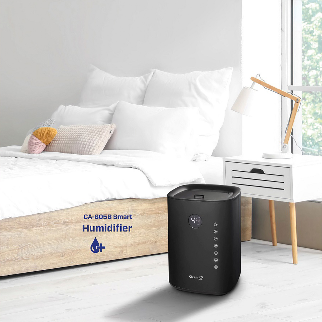 Czarny nawilżacz CA-605B Smart na drewnianej ramie łóżka, obok lampy, biały pokój.