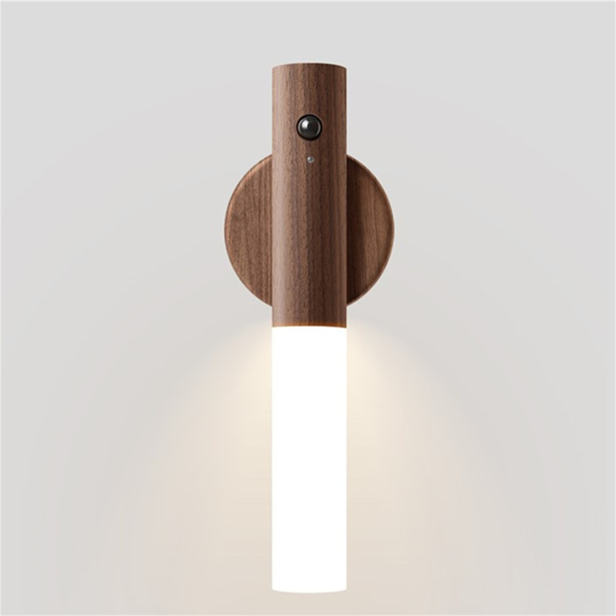Eine Wandlampe mit Holzkorpus und zylindrischer Lichtquelle, die Licht nach unten abstrahlt.