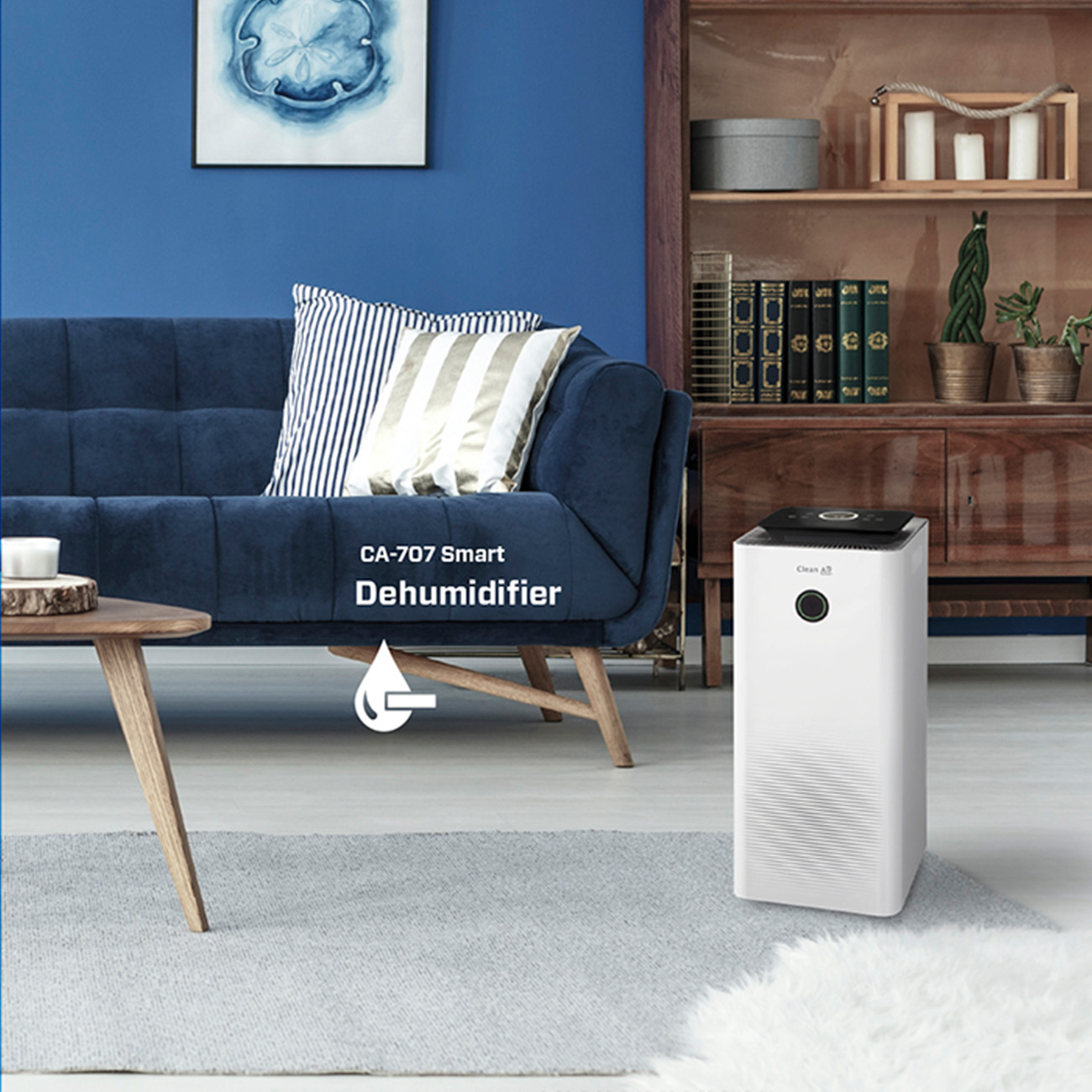 Ein weißer Luftentfeuchter steht in einem Wohnzimmer. Es gibt ein blaues Sofa und einen hölzernen Beistelltisch.