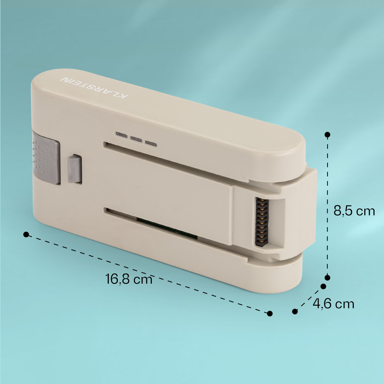 Un elettrodomestico beige con dimensioni è su una superficie verde acqua.