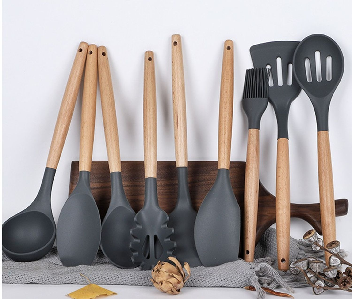 Ein Set Küchenutensilien, darunter Löffel, ein Spatel und ein Pinsel, alle mit Holzgriffen.