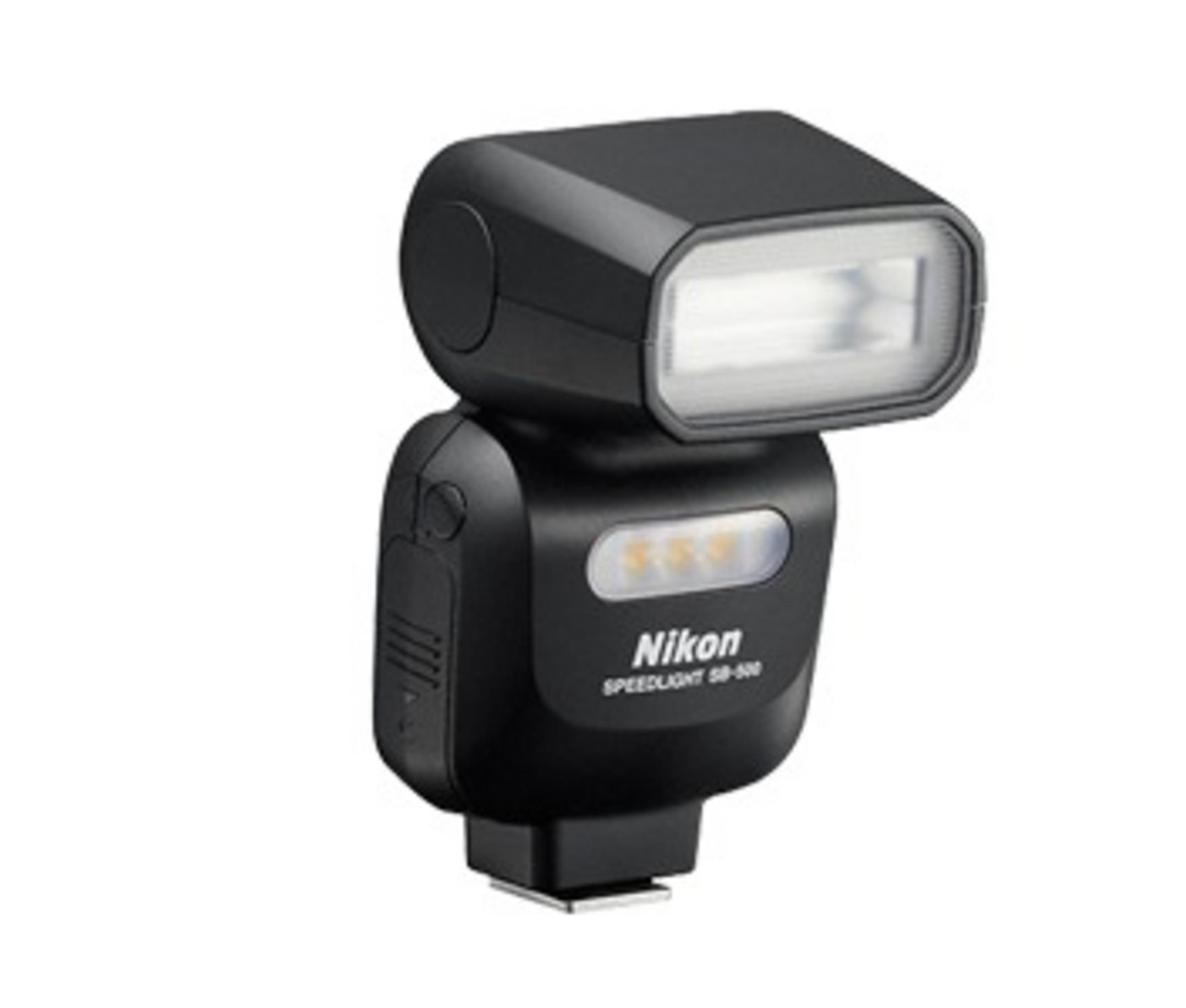 Ein schwarzes Nikon Speedlight SB-500 Blitzgerät auf weißer Oberfläche, schräg.