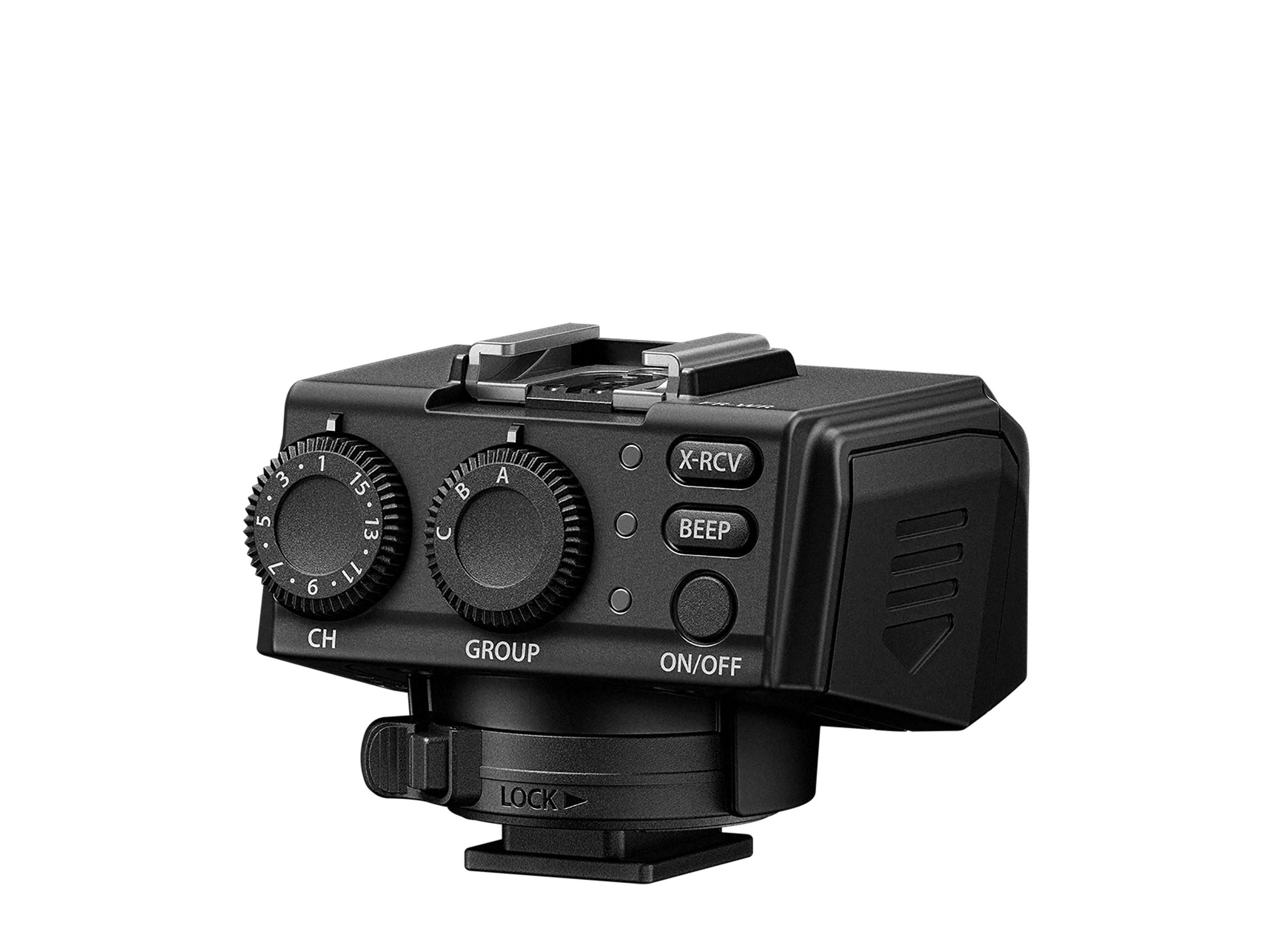 Czarny wyzwalacz lampy błyskowej z przyciskami i pokrętłami. Zawiera funkcję 'blokady' i 'wł./wył.'. Izolowany na białym.