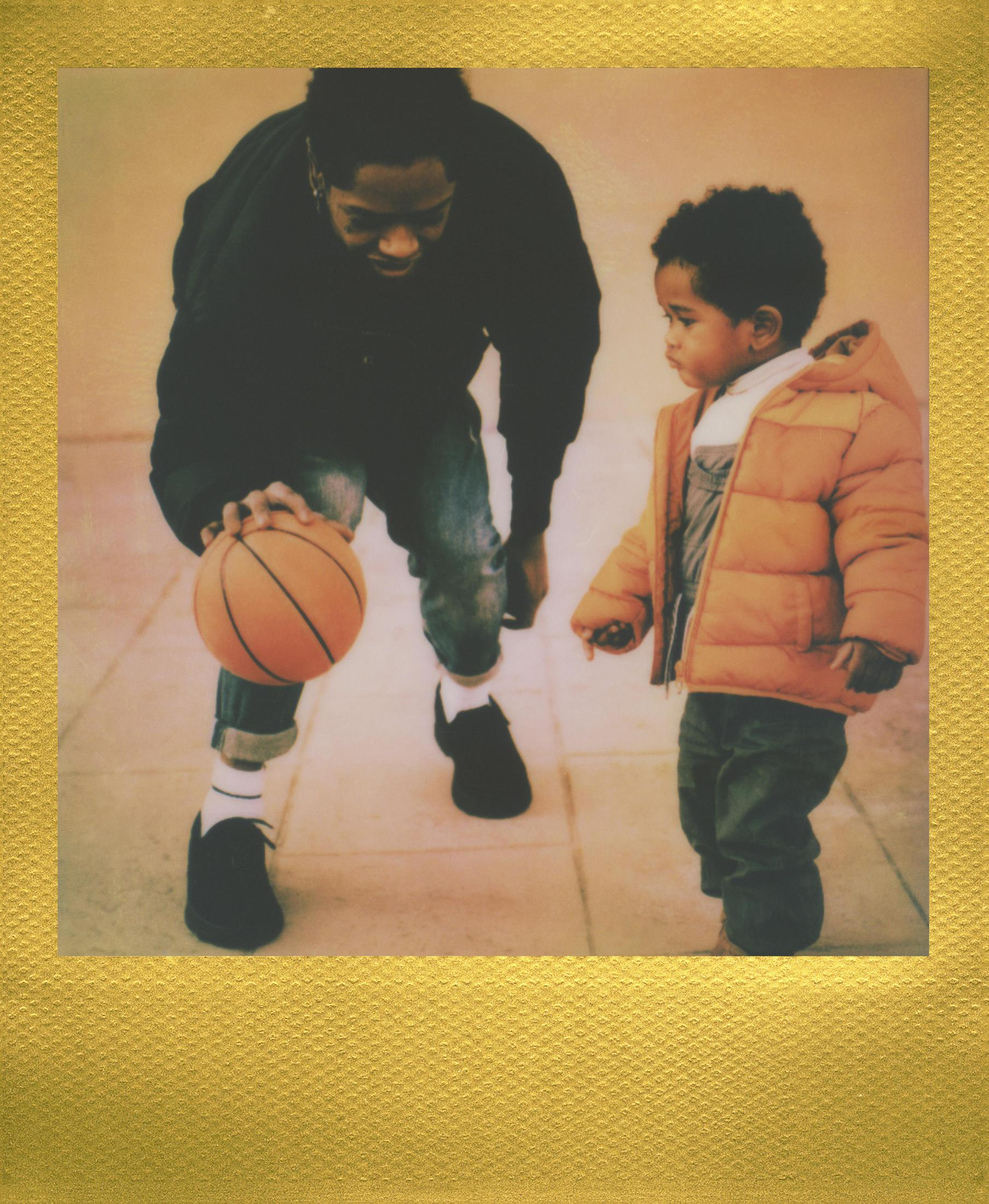 Un uomo e un bambino giocano a basket, presentati come un'immagine Polaroid vintage.