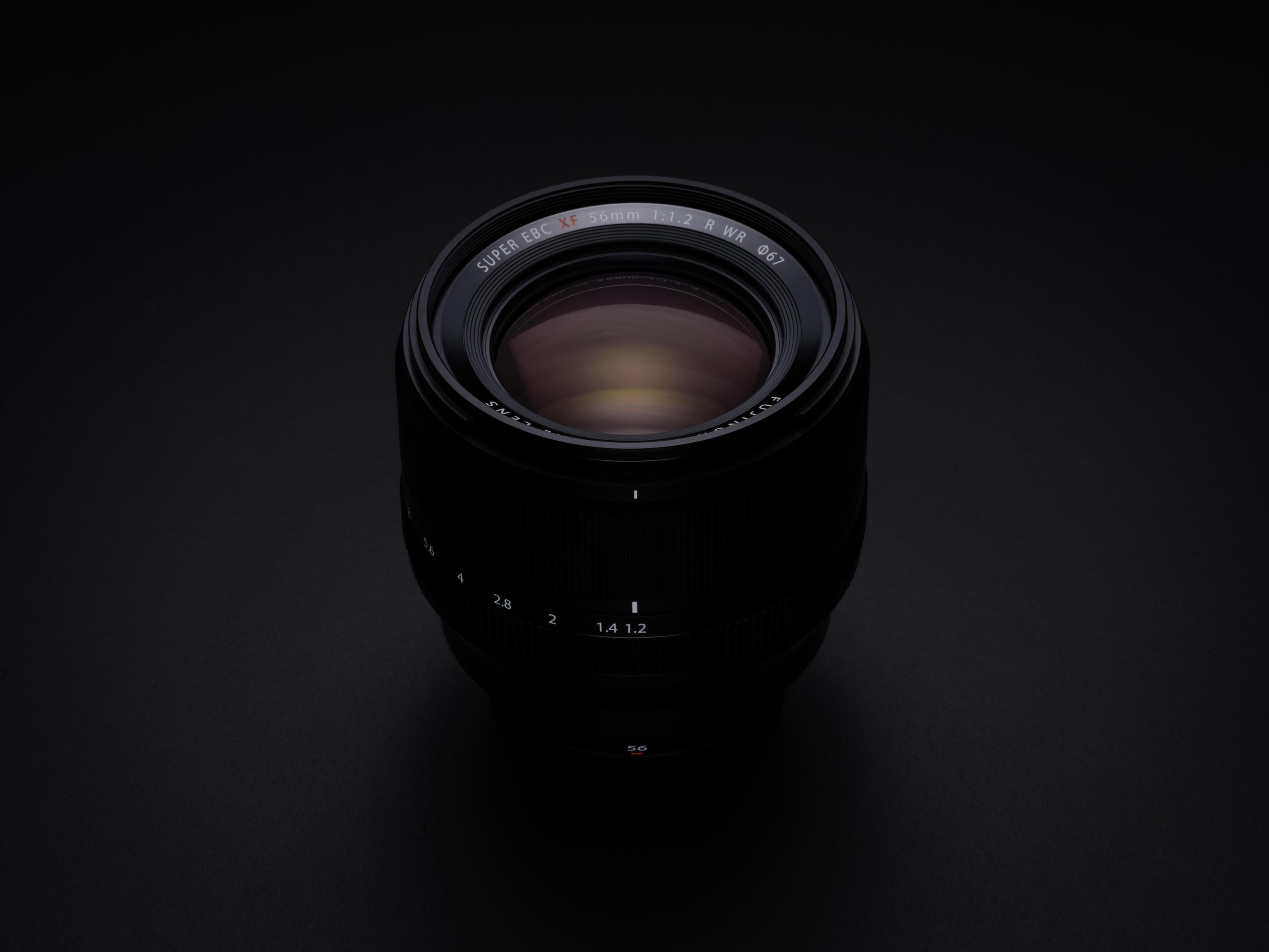 Czarny obiektyw na czarnym tle. Tekst: SUPER EBC XF 56mm 1:1.2 R WR.