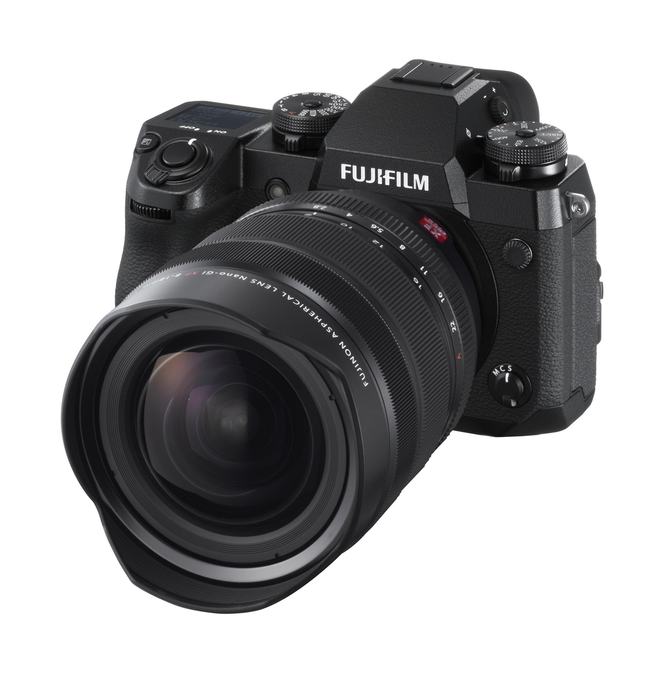 Schwarze Fujifilm-Kamera mit Objektiv, abgewinkelt zum Betrachter, zeigt die Vorderseite der Kamera.