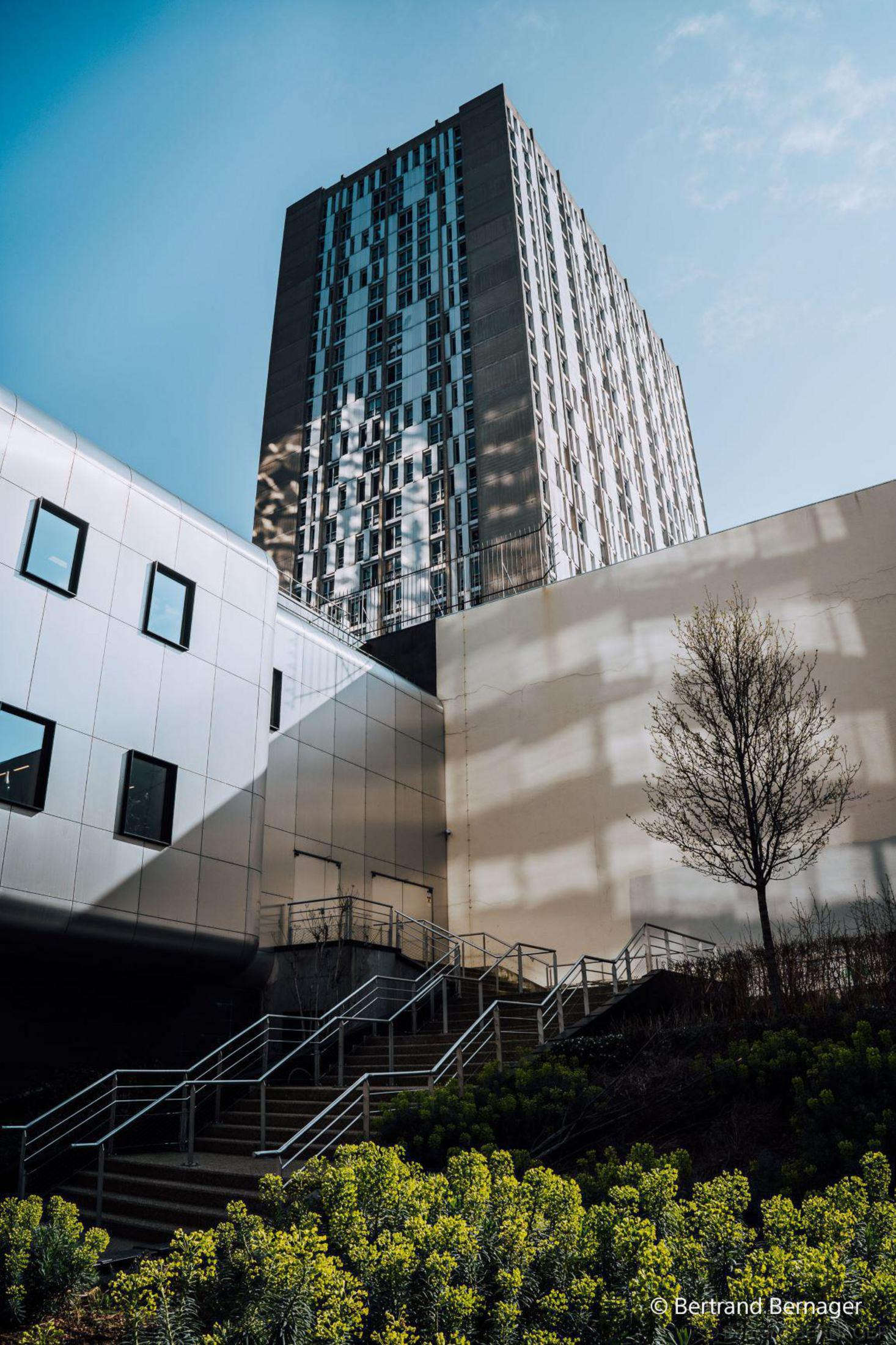 Wysoki budynek o nowoczesnym designie na tle czystego, błękitnego nieba.