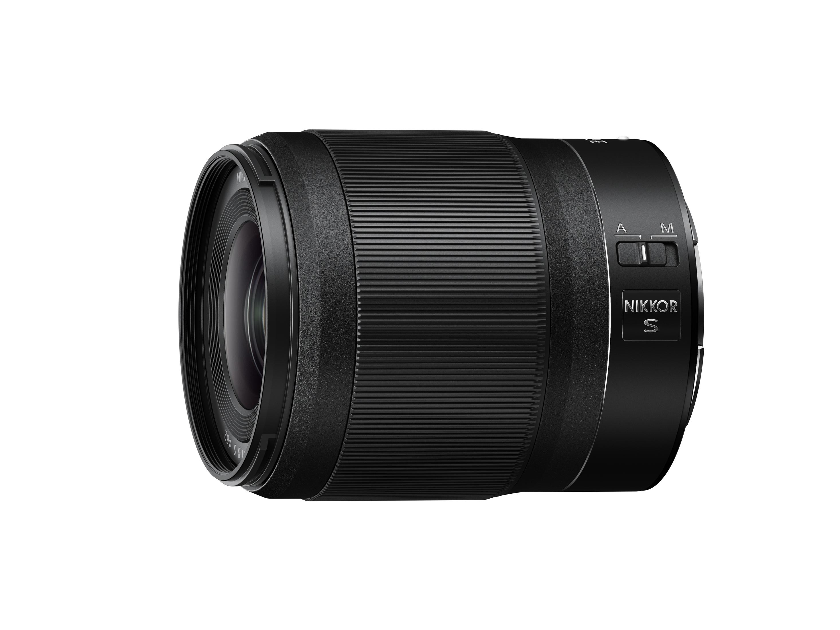 Schwarzes Kameraobjektiv. Es hat Text auf der Seite: NIKKOR S. Das Objektiv ist auf weißem Grund.