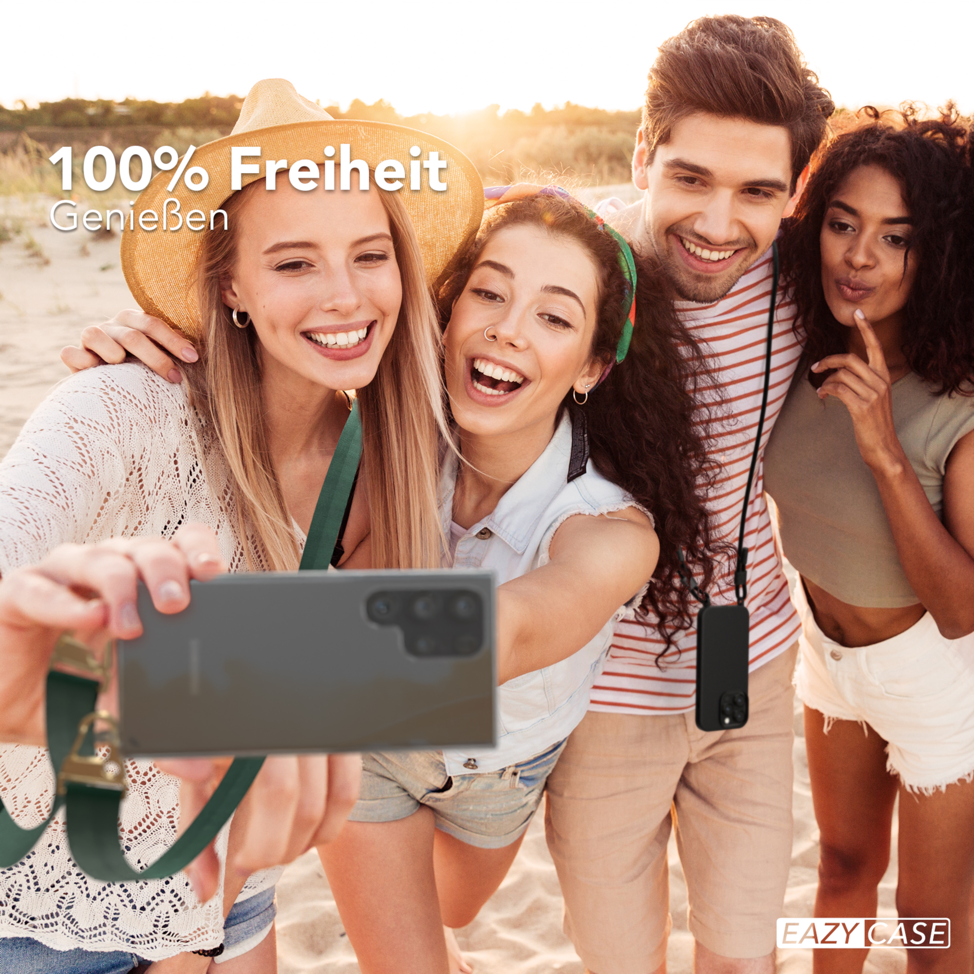 Vier Leute am Strand machen ein Selfie. Sie lächeln und halten ein Smartphone.