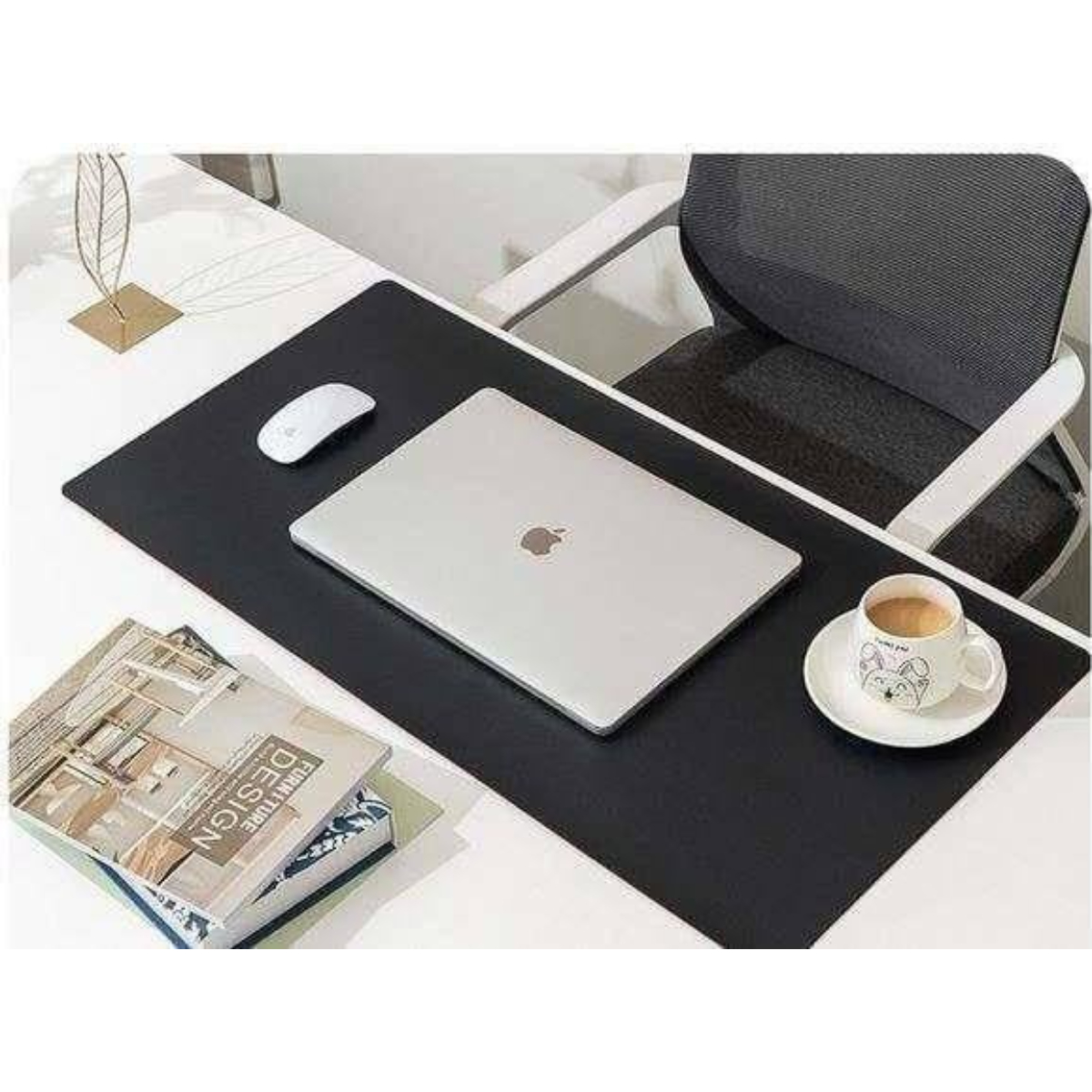 Schreibtischszene: schwarze Schreibtischunterlage mit Laptop, Maus, Büchern und Kaffeebecher.