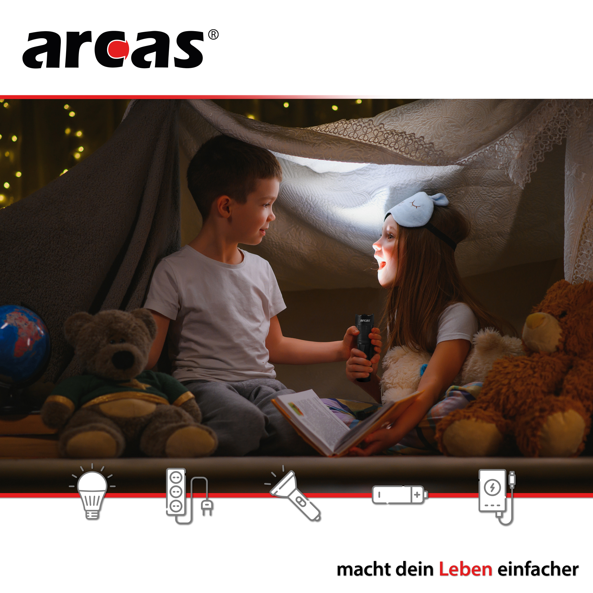 Due bambini in una tenda, uno tiene una torcia, leggendo un libro. Orsacchiotti e luci sono visibili.