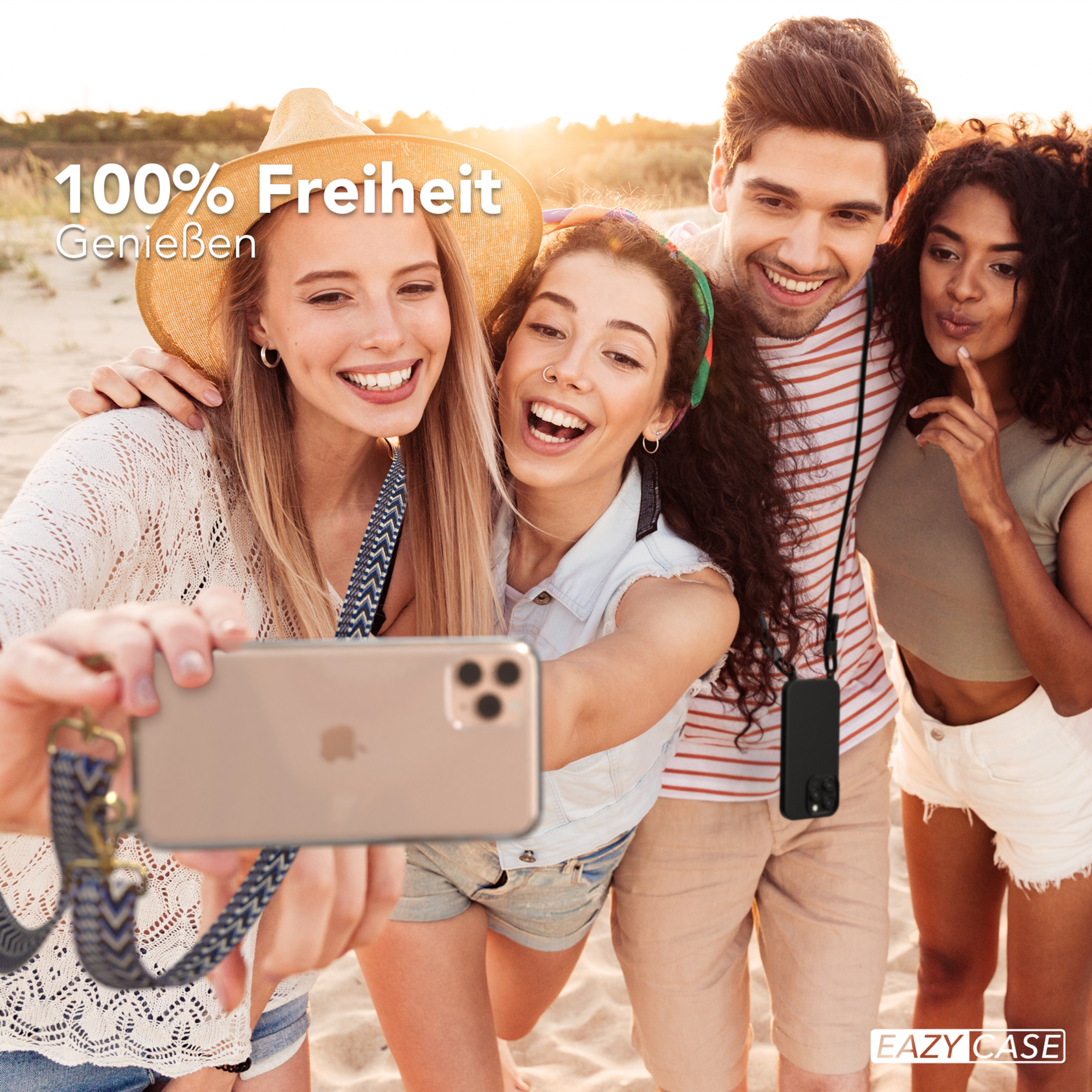 Vier Personen machen ein Selfie am Strand. Zwei Frauen und zwei Männer lächeln und halten ein Handy mit Umhängeband.