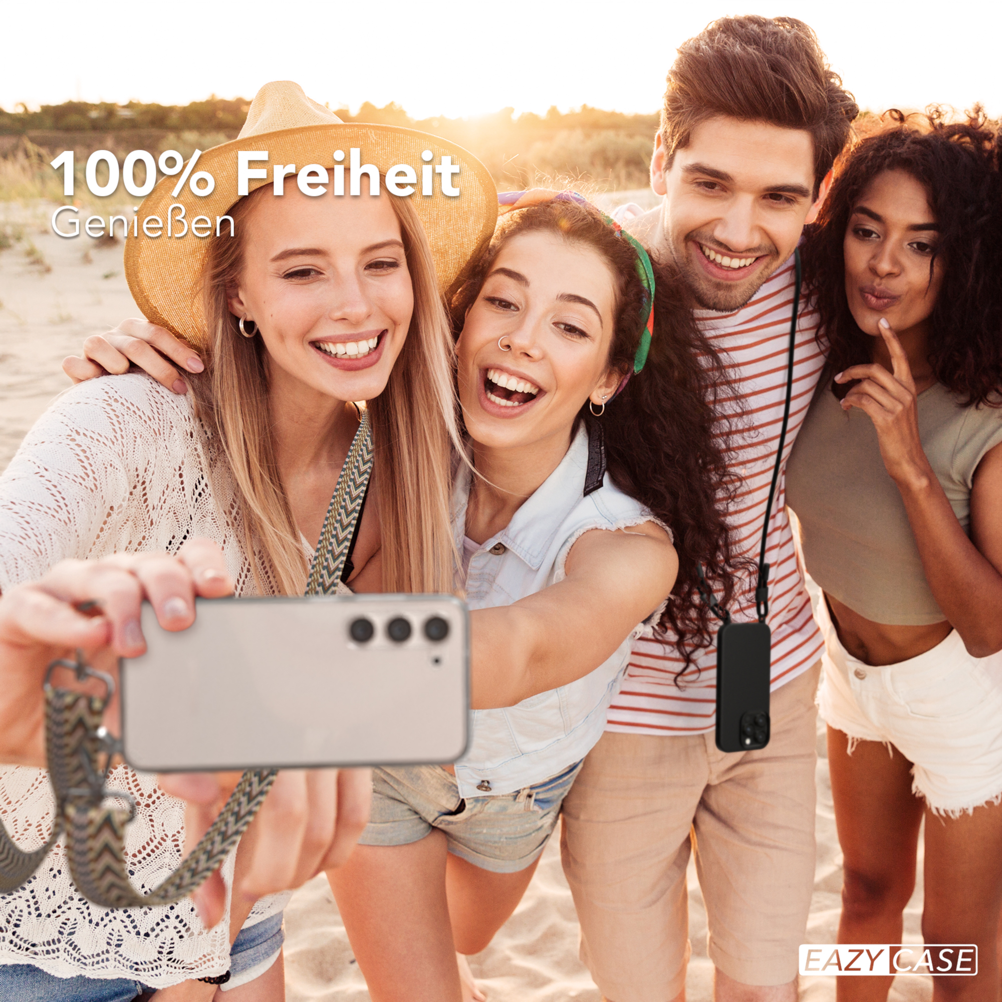 Vier Personen machen ein Selfie am Strand. Sie lächeln und halten ein Telefon mit einem Band.