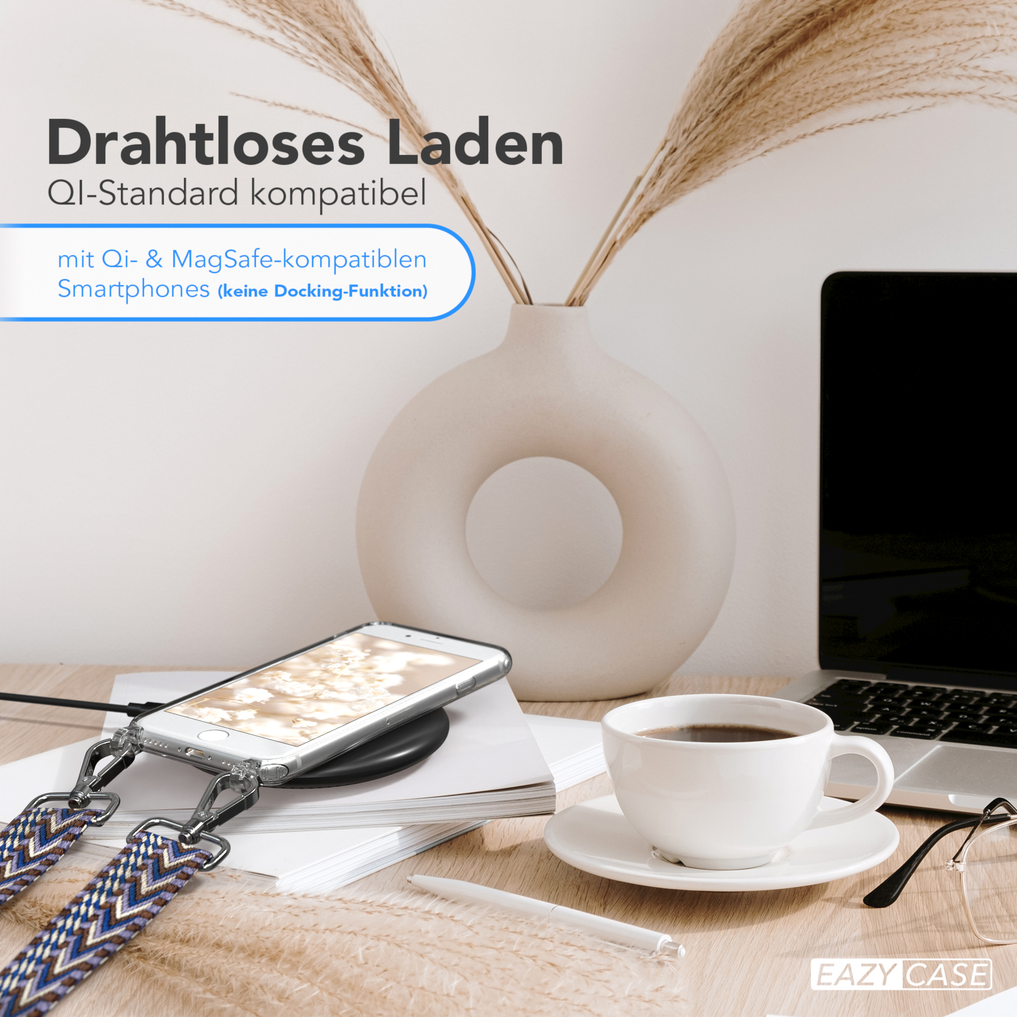 Ein Telefon auf einem kabellosen Ladegerät, Kaffee, Pflanzen und eine Brille auf einem Schreibtisch.