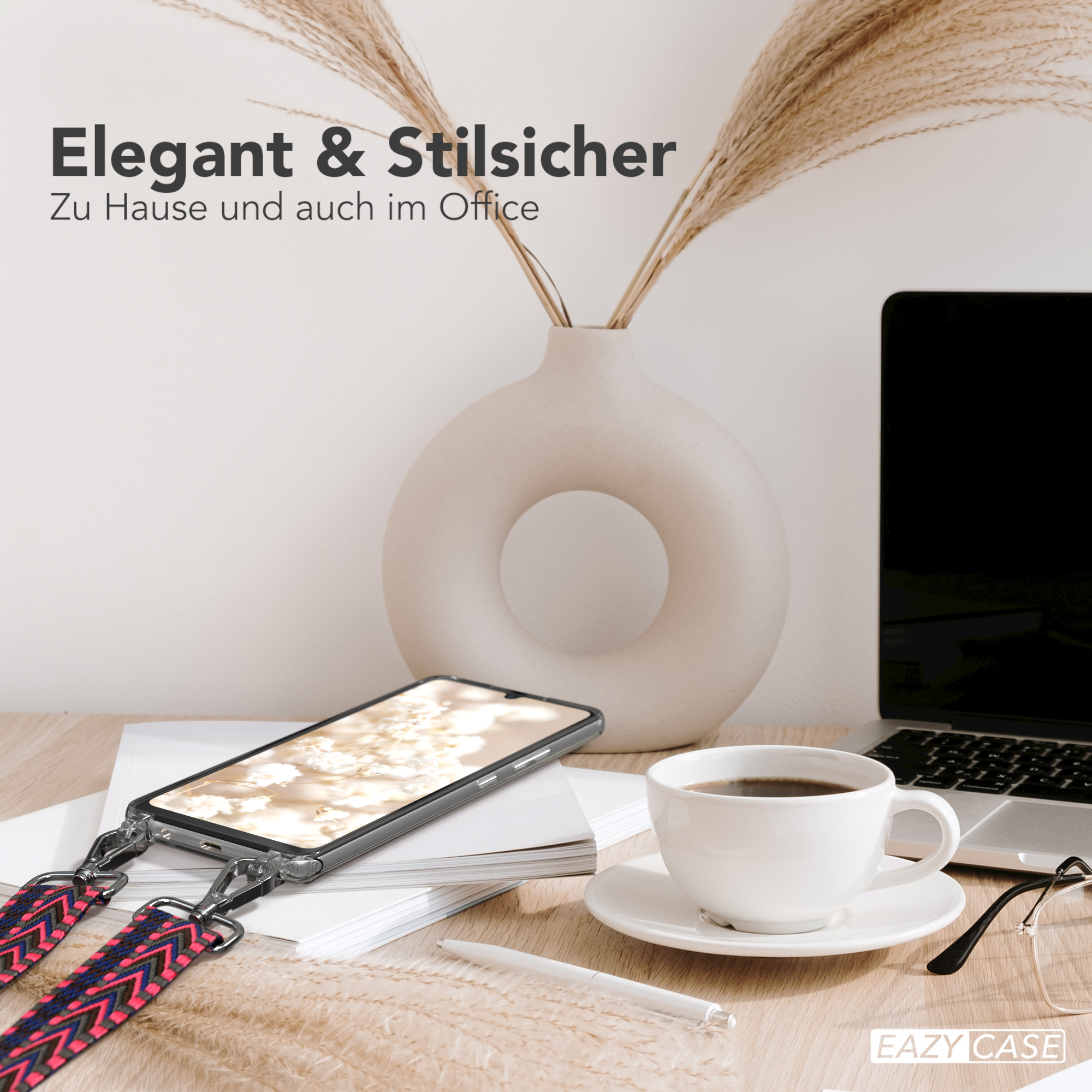 Telefon mit Riemen auf einem Schreibtisch. Kaffeetasse und Laptop sind ebenfalls vorhanden. Eine Vase und Pflanzen im Hintergrund.