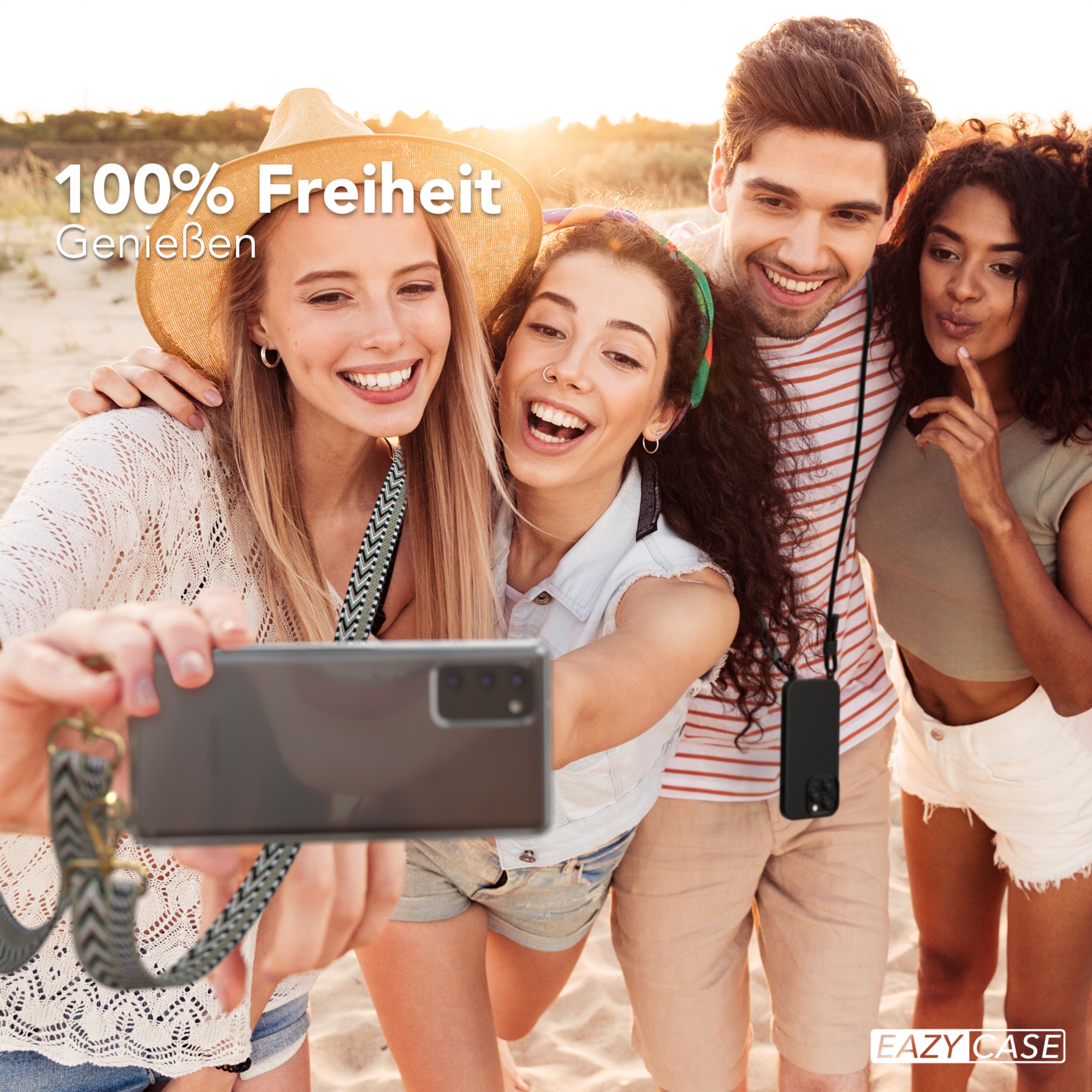 Vier Personen machen Selfie. Einer hält Telefon mit Riemen. Alle lächeln.